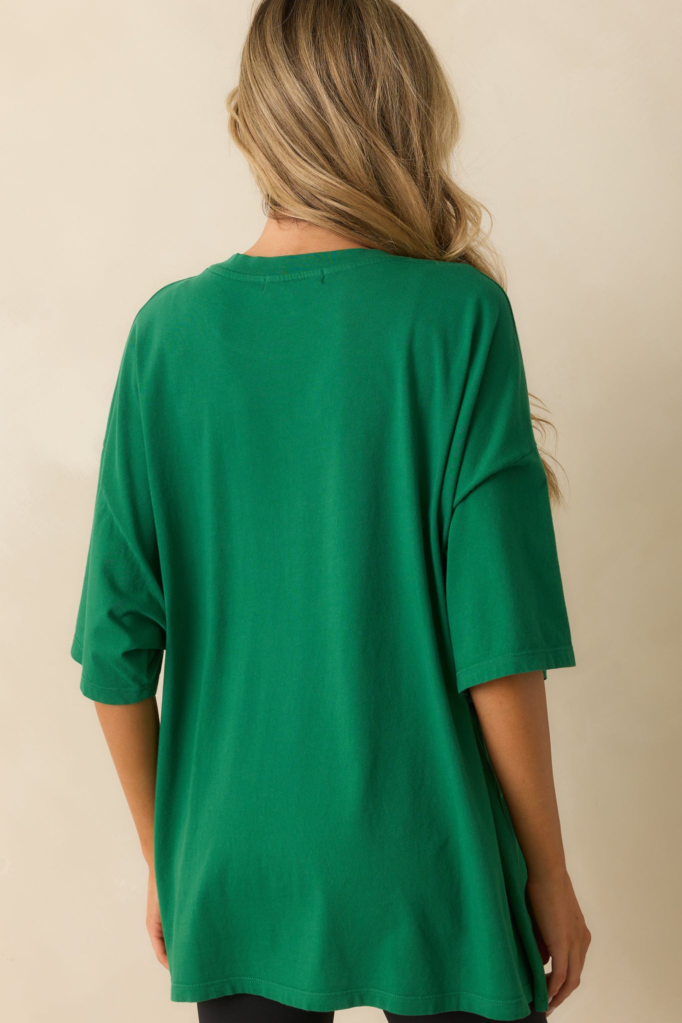 A back view of the tee displaying the plain green back and relaxed oversized cut.