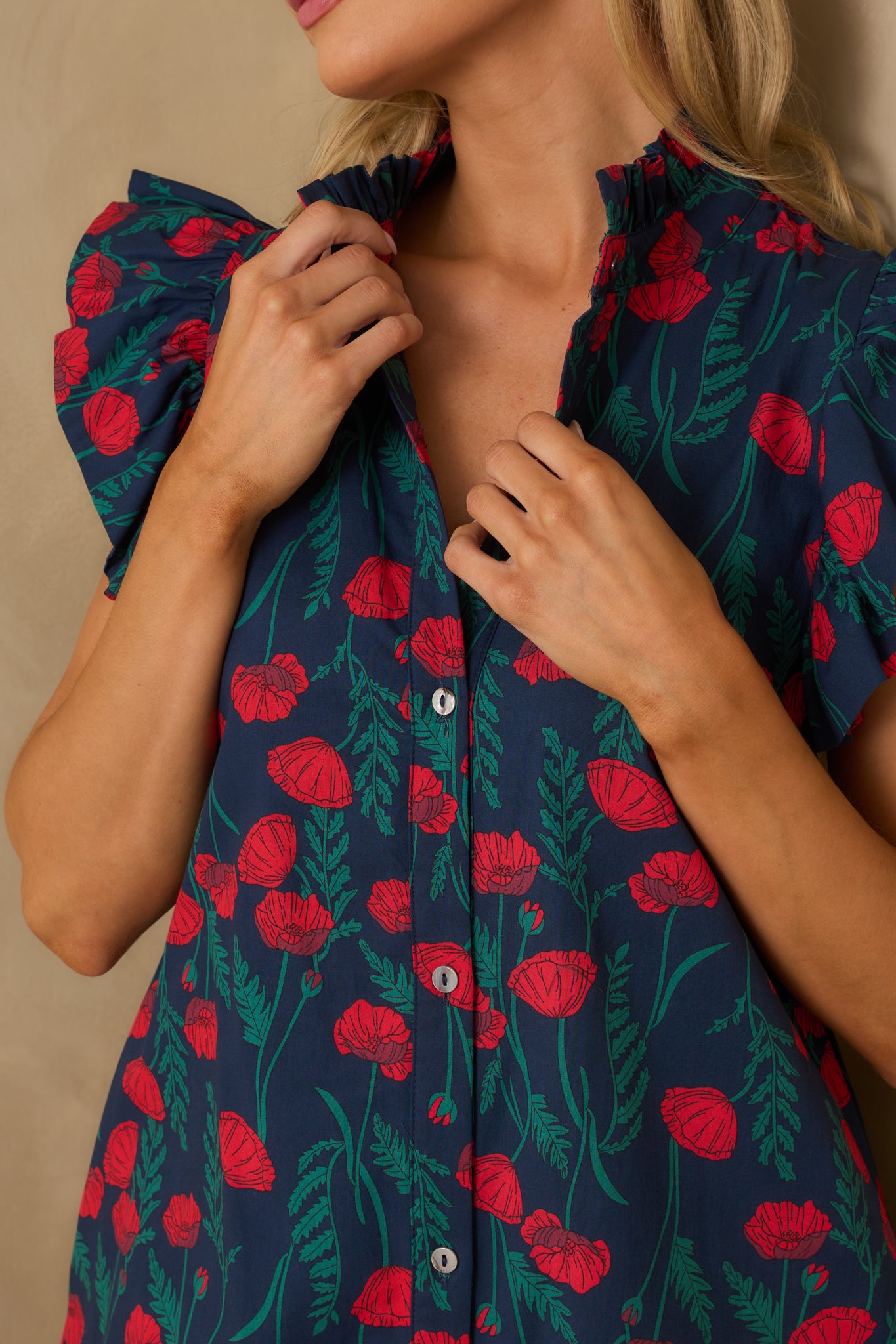 Detailed view of the button front and ruffle neckline against the floral print.