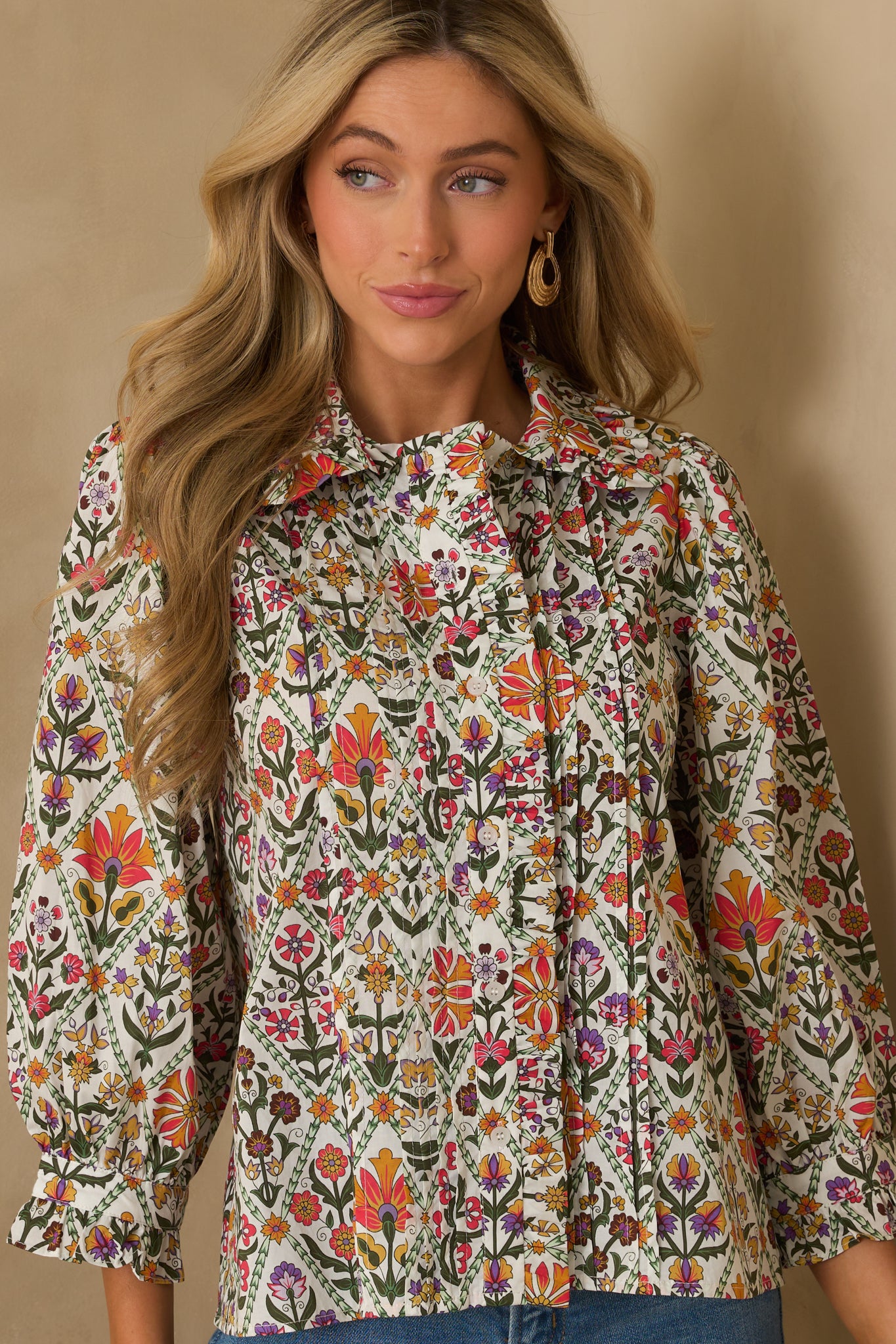 A cropped image focusing on the pintuck detailing and geometric floral print of the cotton blouse.
