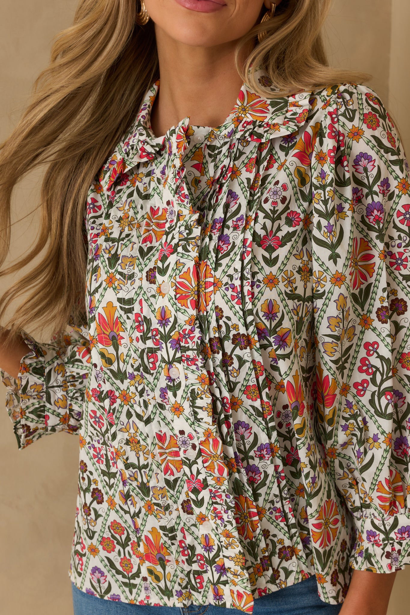 A cropped view highlighting the ruffled collar neckline and button front of the floral cotton top.