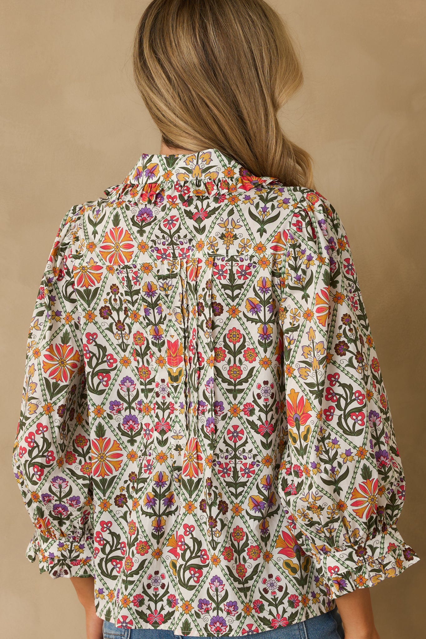 A back view of the cotton blouse with a multicolor geometric floral print and relaxed fit.