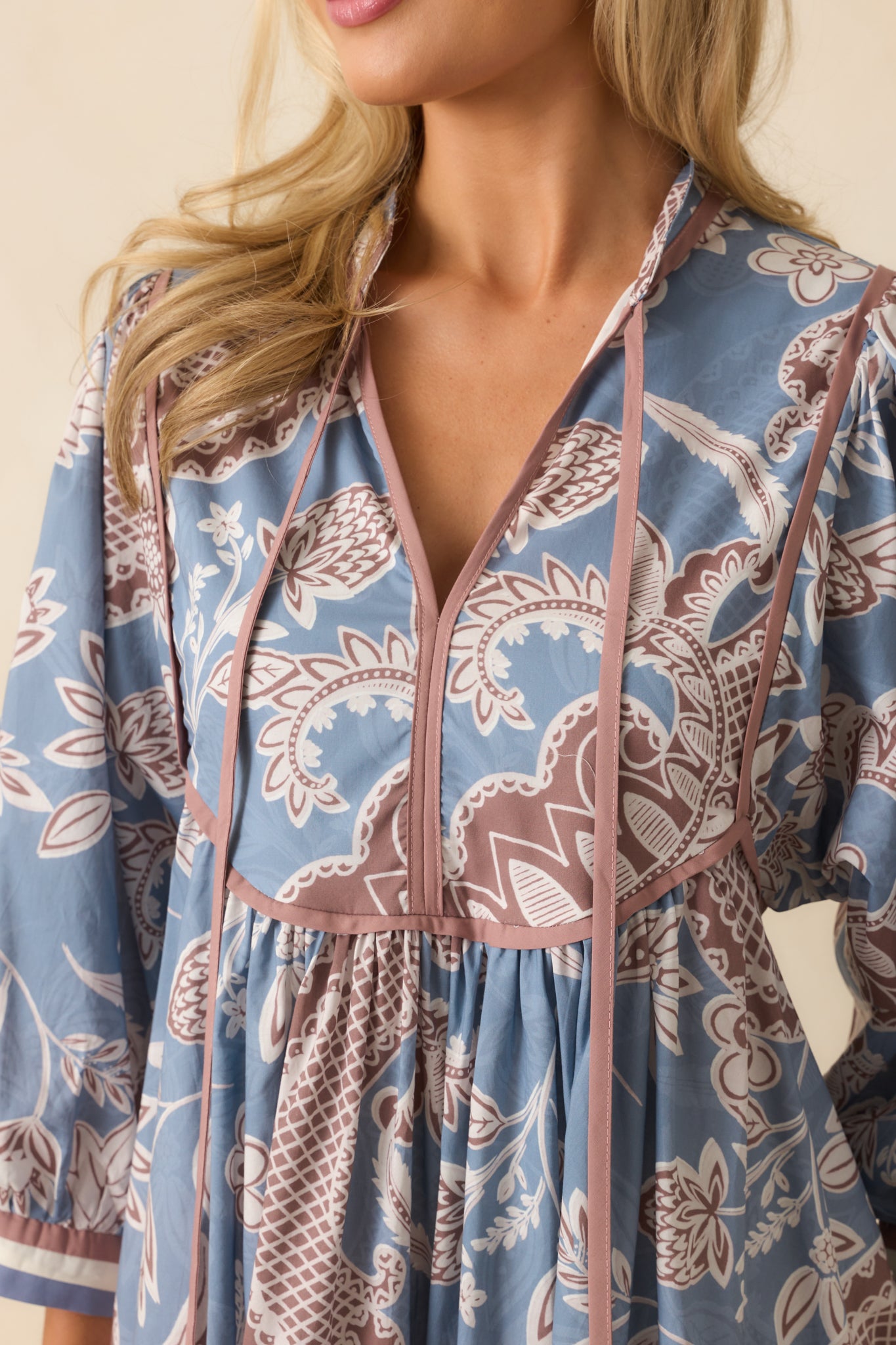 Detailed shot of the split v-neckline, optional self-tie, and intricate floral paisley print.