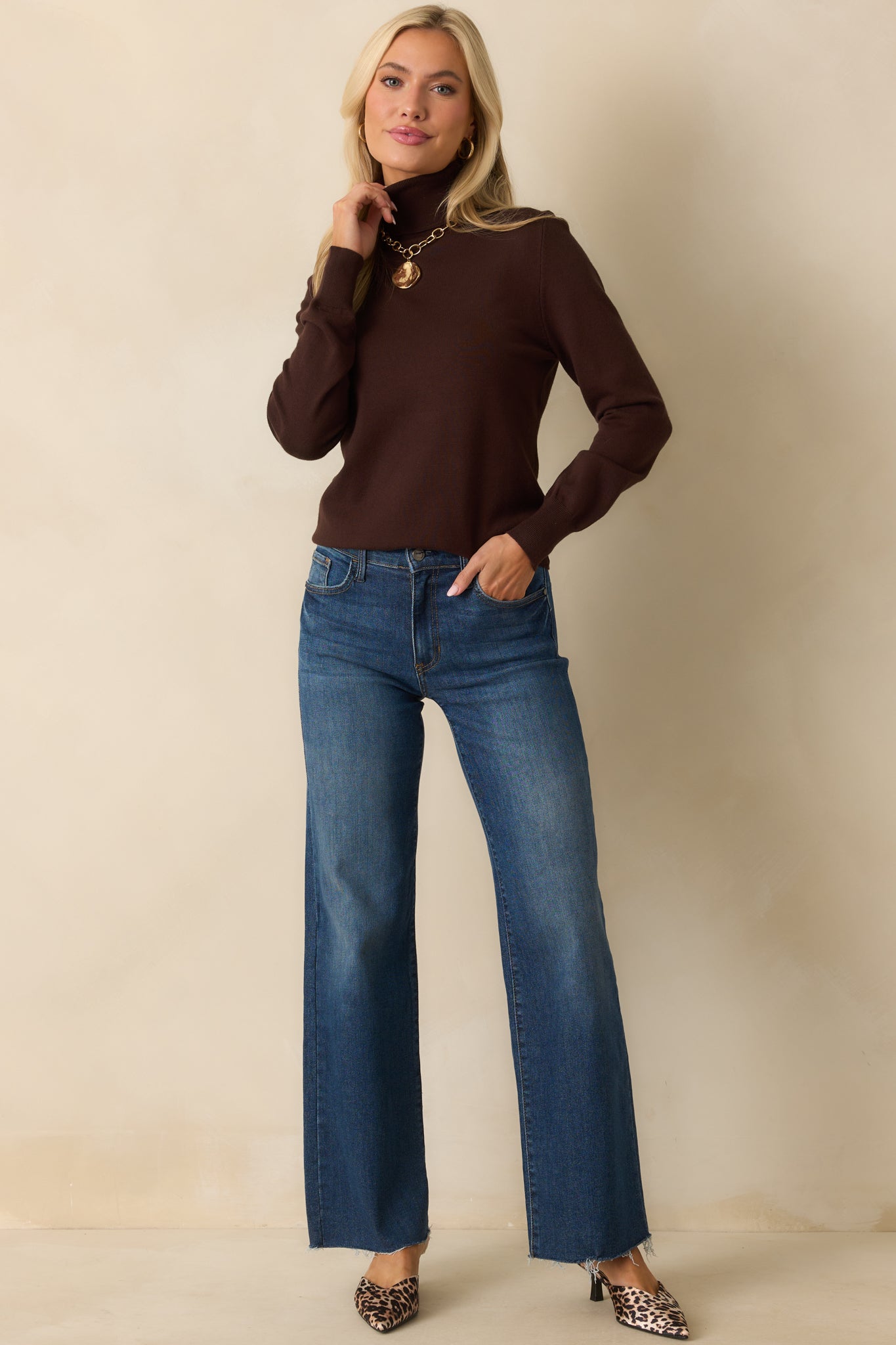 A full body view of the brown sweater highlighting the ribbed bottom hem that tapers at the waist.
