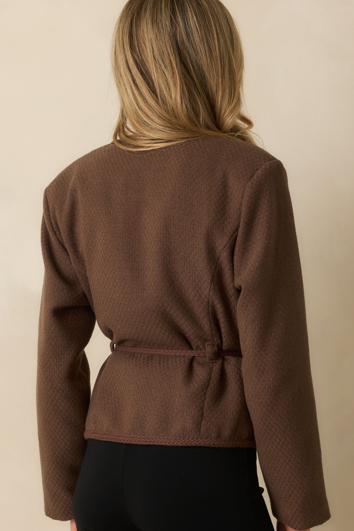 A back view of the jacket showing the clean tailored cut and braided trim accents.