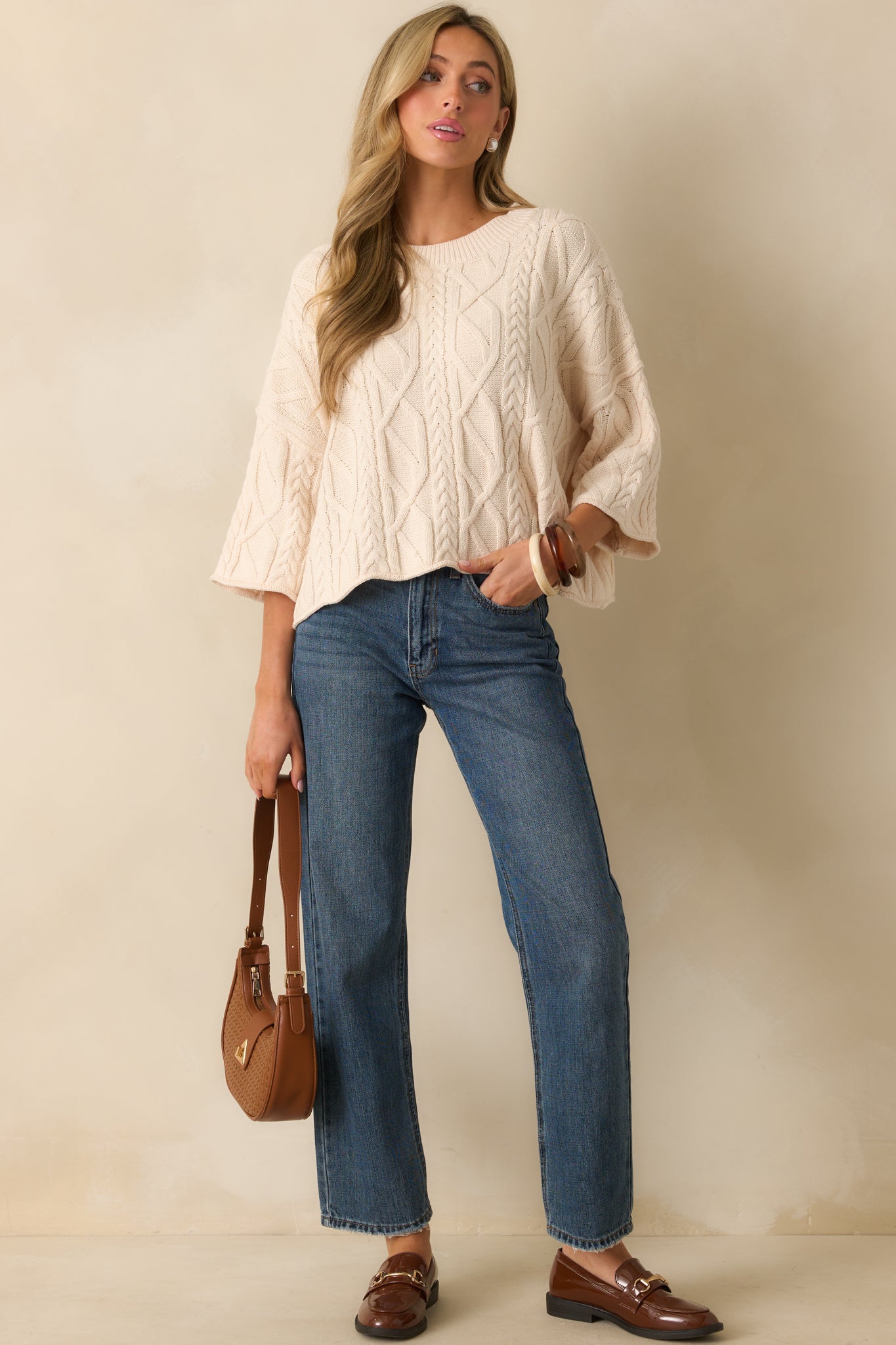 A full body front-facing view highlighting the cable knit pattern and relaxed fit.