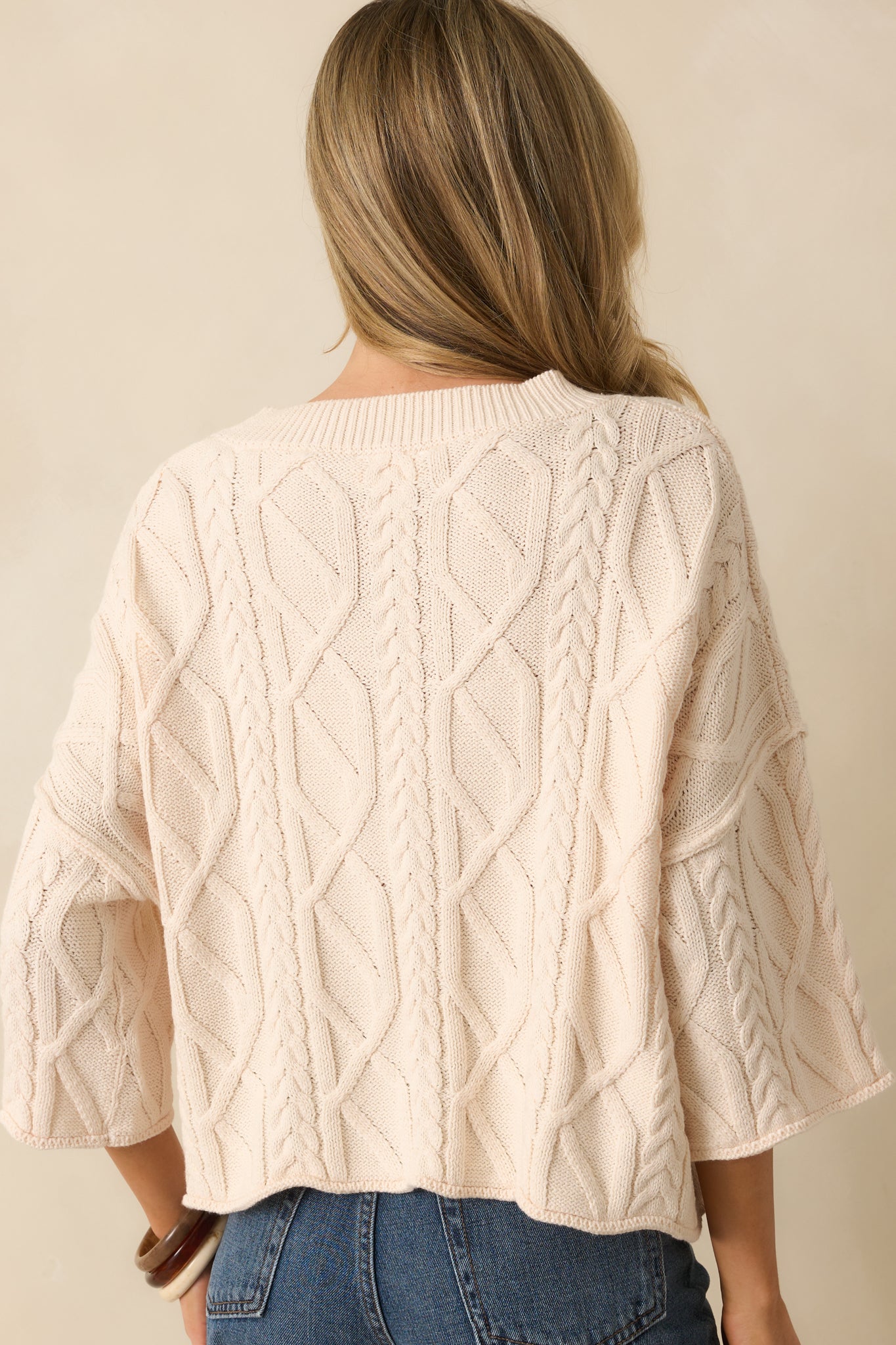 A back view of the sweater showing the relaxed fit and rolled hemline.