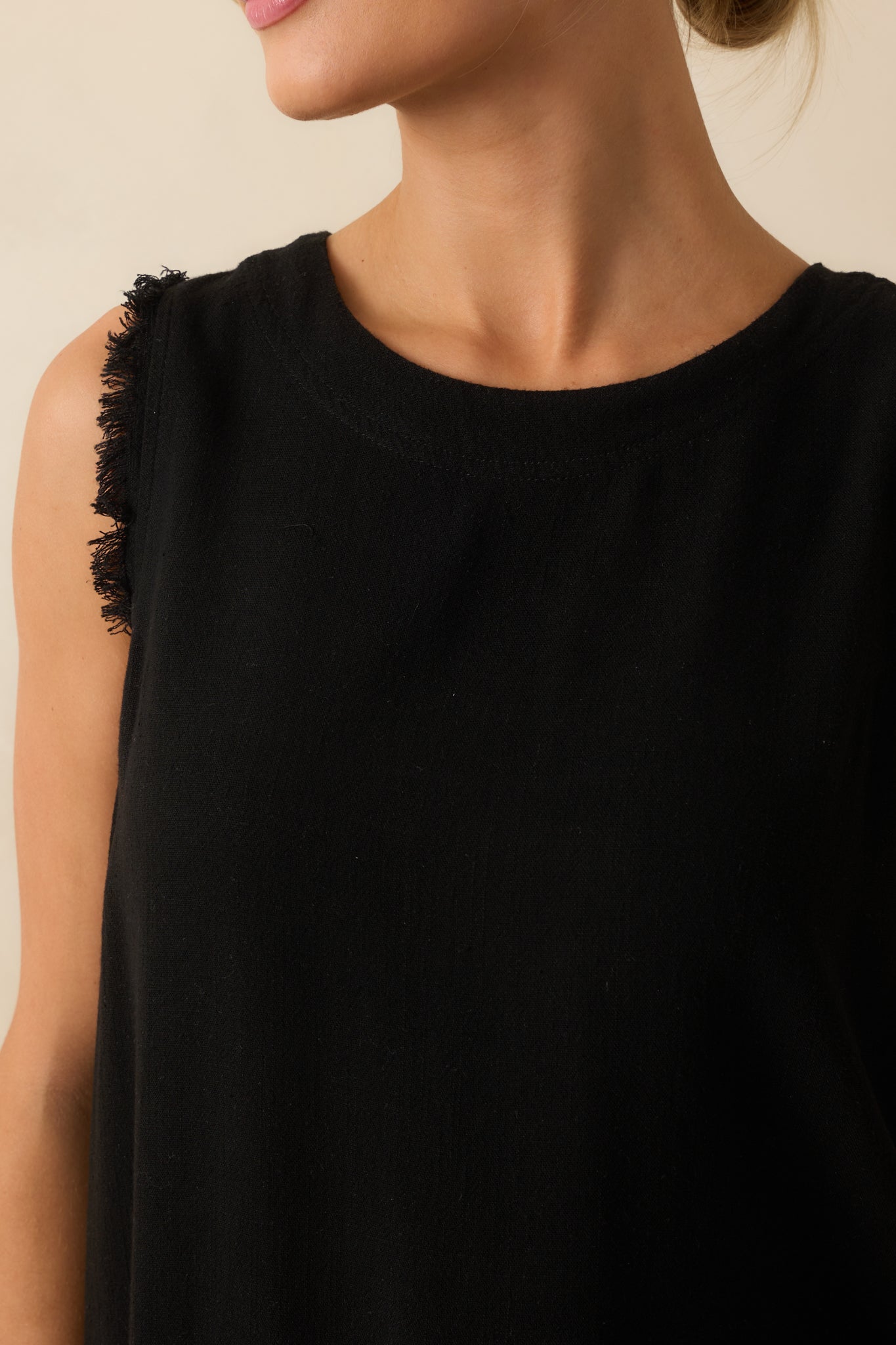 Zoomed-in view of the frayed shoulder and hemline, emphasizing texture and button accents.