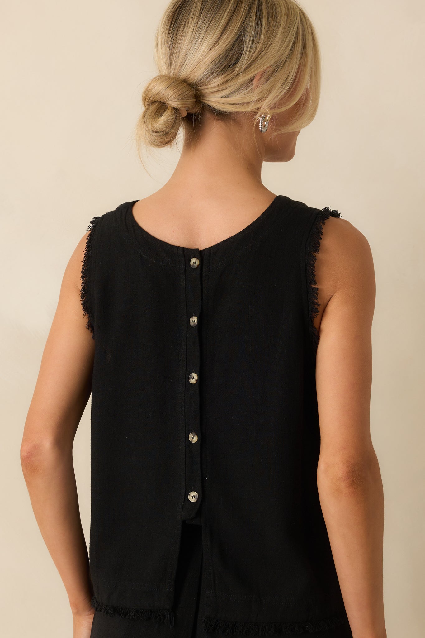 Rear view of the black tank showing functional buttons, frayed shoulders, and frayed hemline.