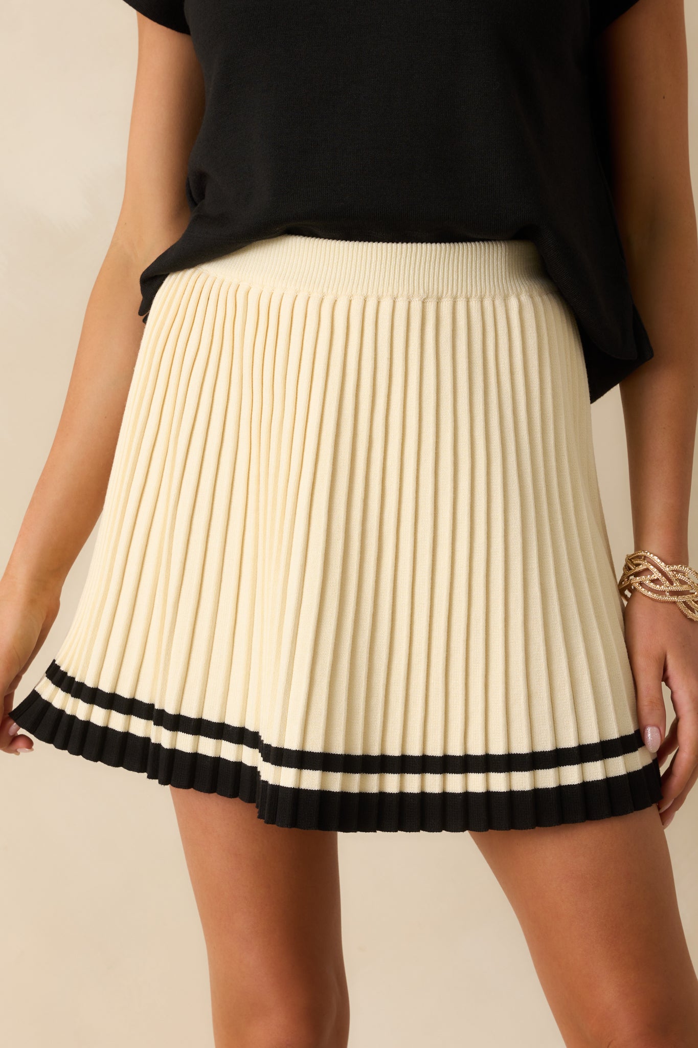 A close-up detail of the pleated fabric and striped bottom hem.