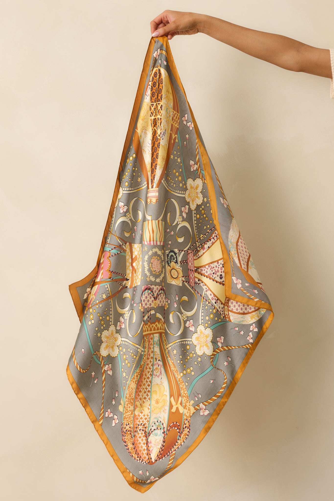 A full view of the square satin scarf unfolded, showcasing the slate gray background and hot air balloon print.