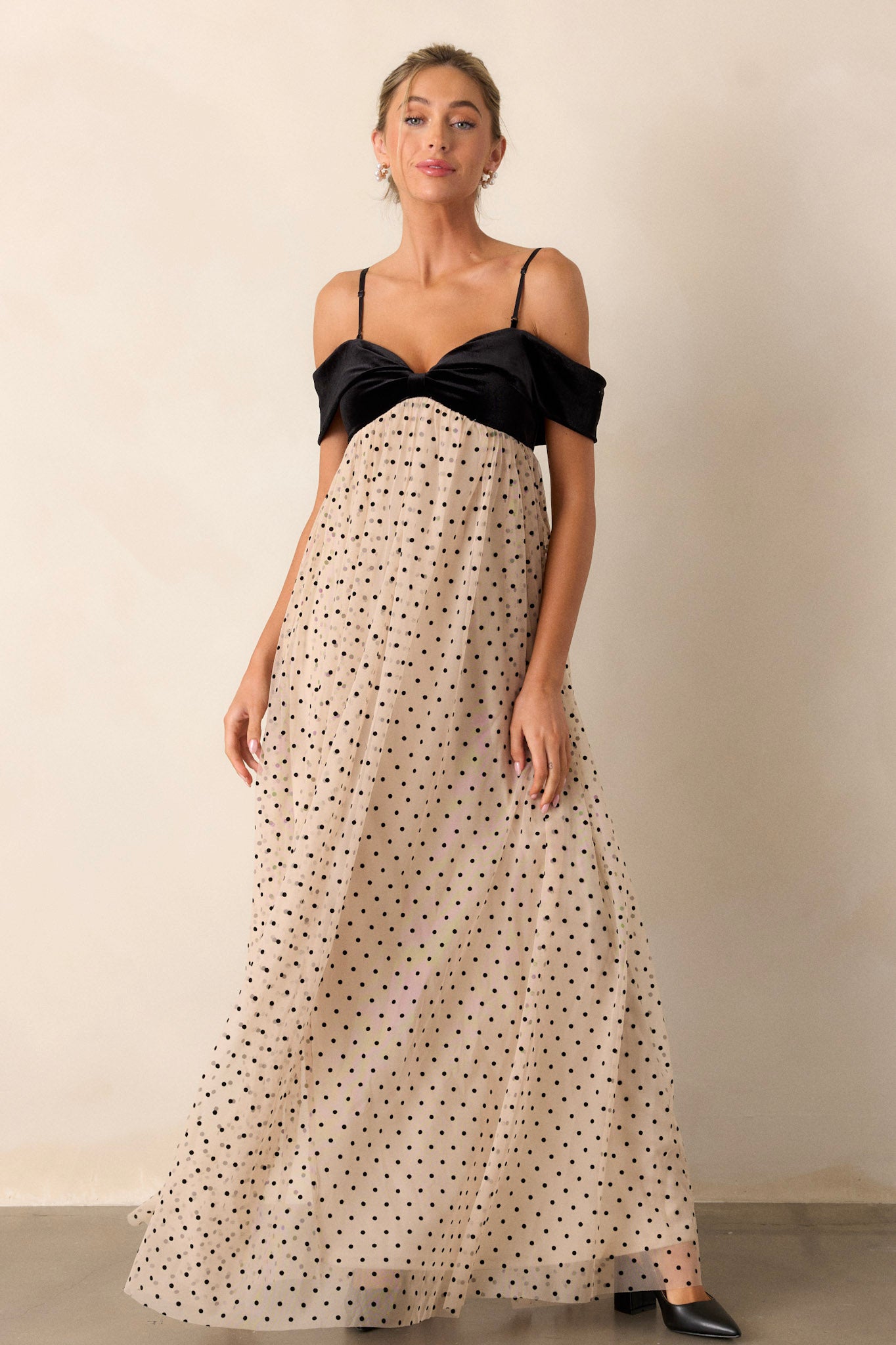 This dress features a velvet bust, a bow-shaped off-the-shoulder design, a flowy polka dot skirt, and a functional back zipper.