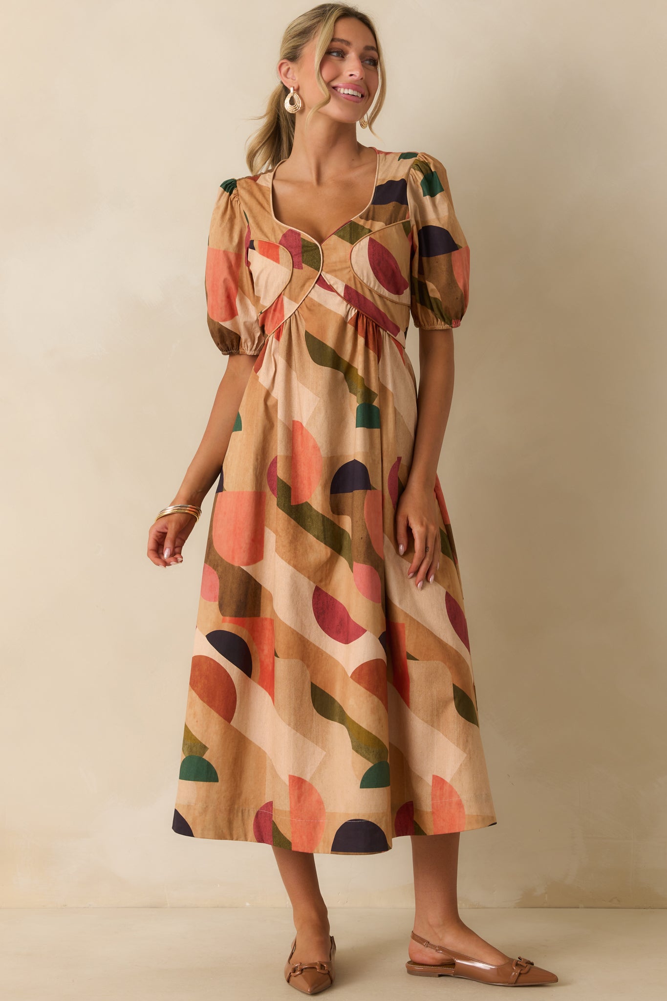 Tan dress with multicolor abstract print and a sweetheart neckline with piping trim.