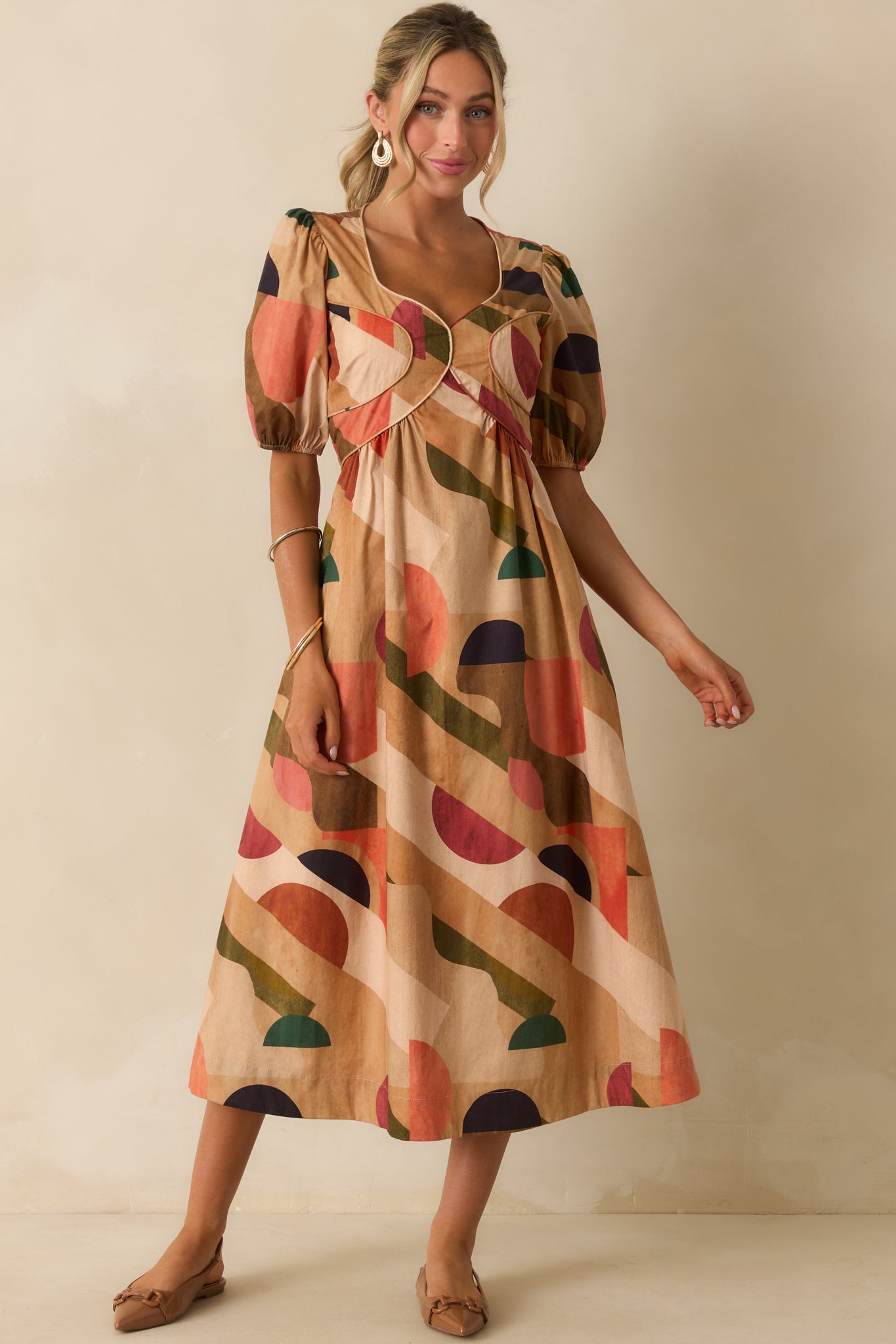 Abstract print dress emphasizing puff sleeves, smocked back, and playful midi hem.