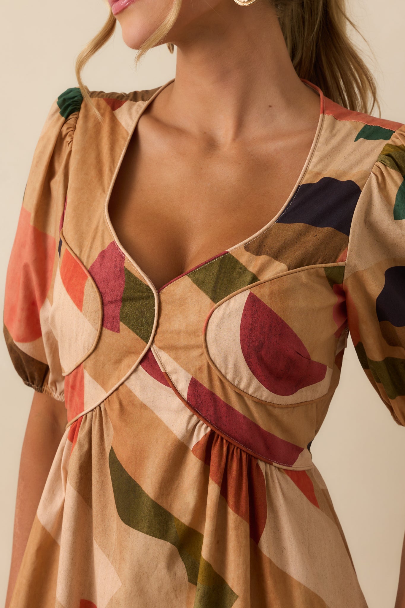 Close-up of the sweetheart neckline with piping trim and fabric print details.