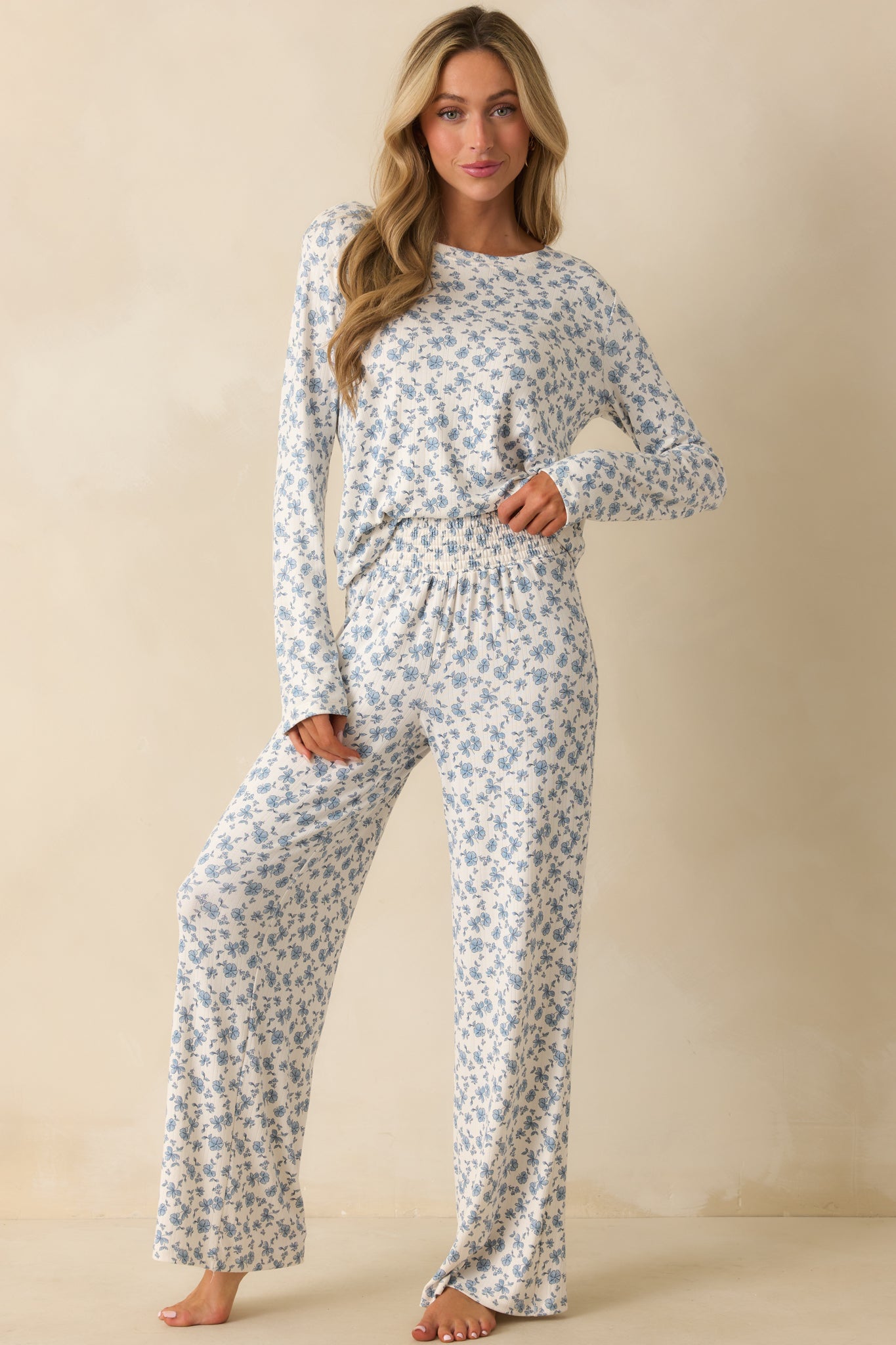 Ivory and blue floral pants with a wide smocked waistband and flowing full-length legs.