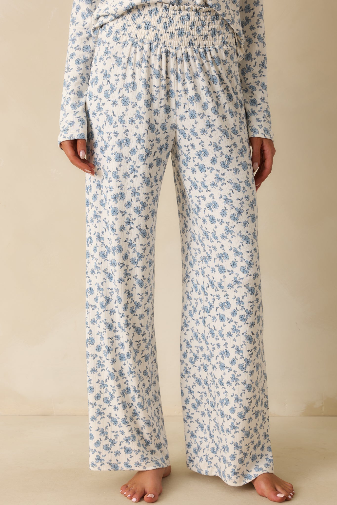 Blue floral pattern highlighted on the ivory fabric with soft flowing lines.