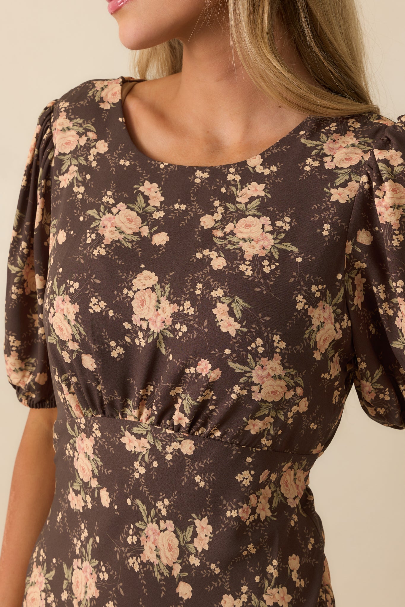 Detailed view of the pink and green floral print on the chocolate brown fabric.