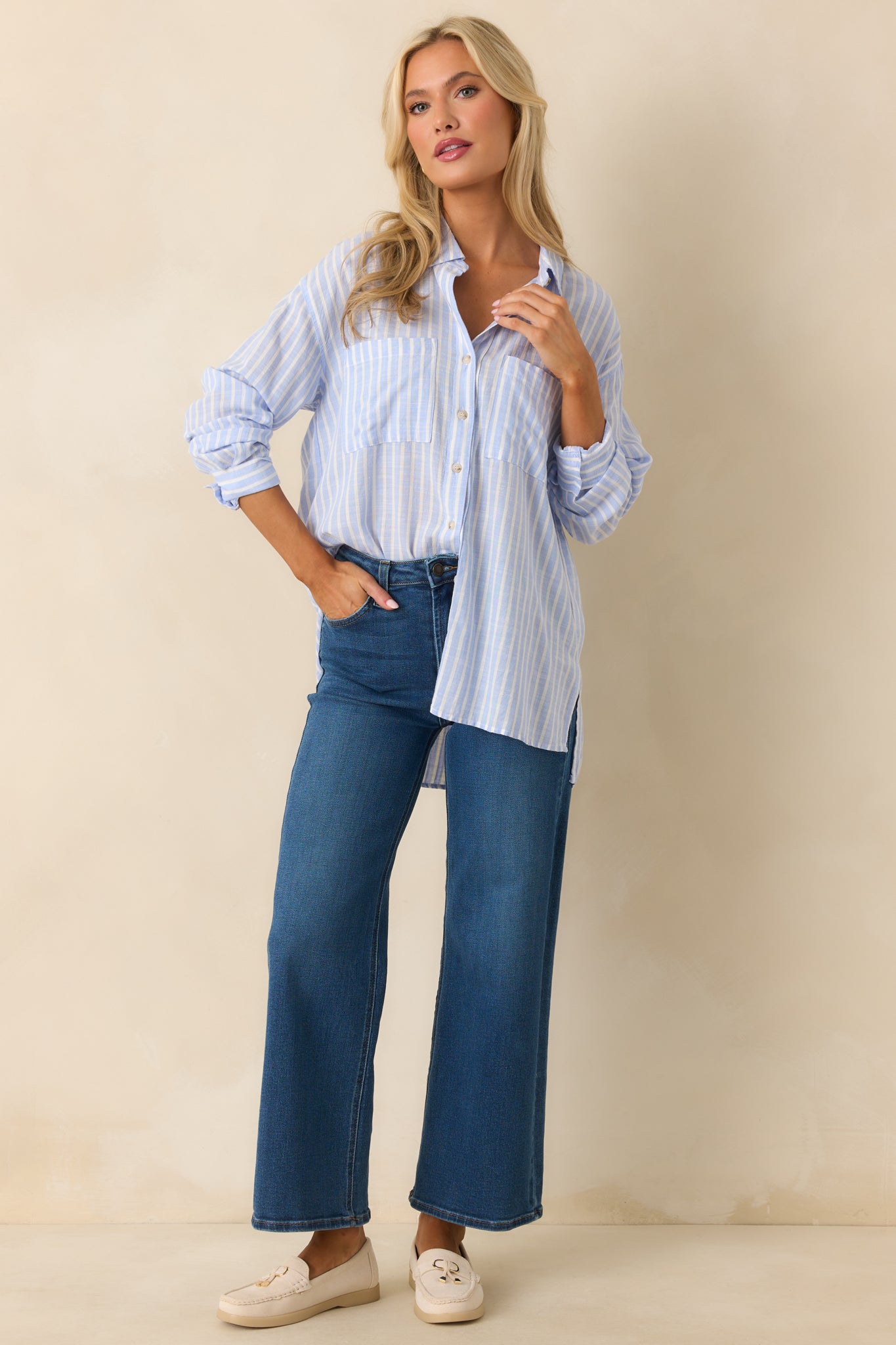 The blue stripe top shown front-facing with a collared neckline and button front design.