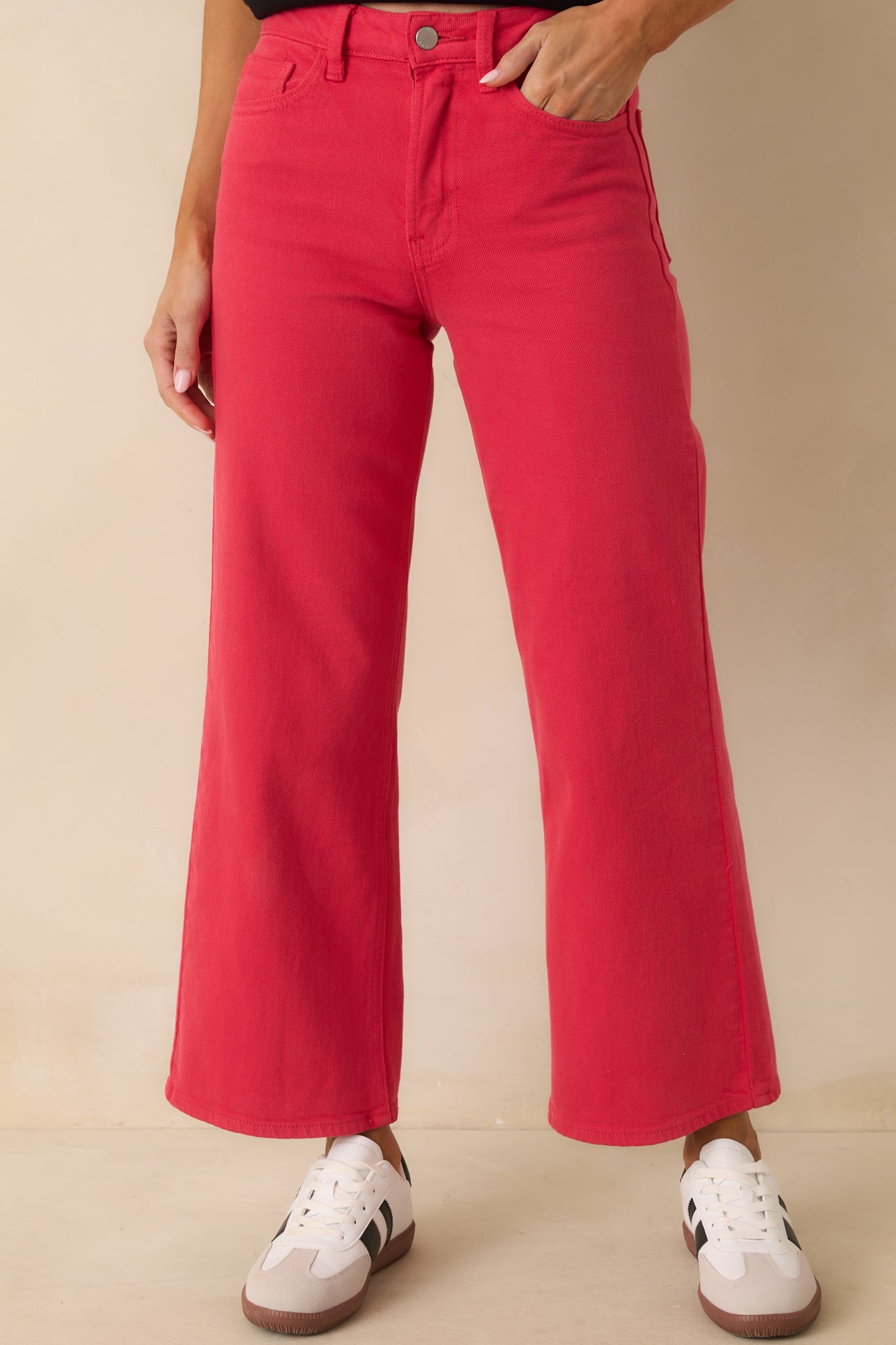 Red high-waisted jeans with cropped length styled with front button and zipper closure.