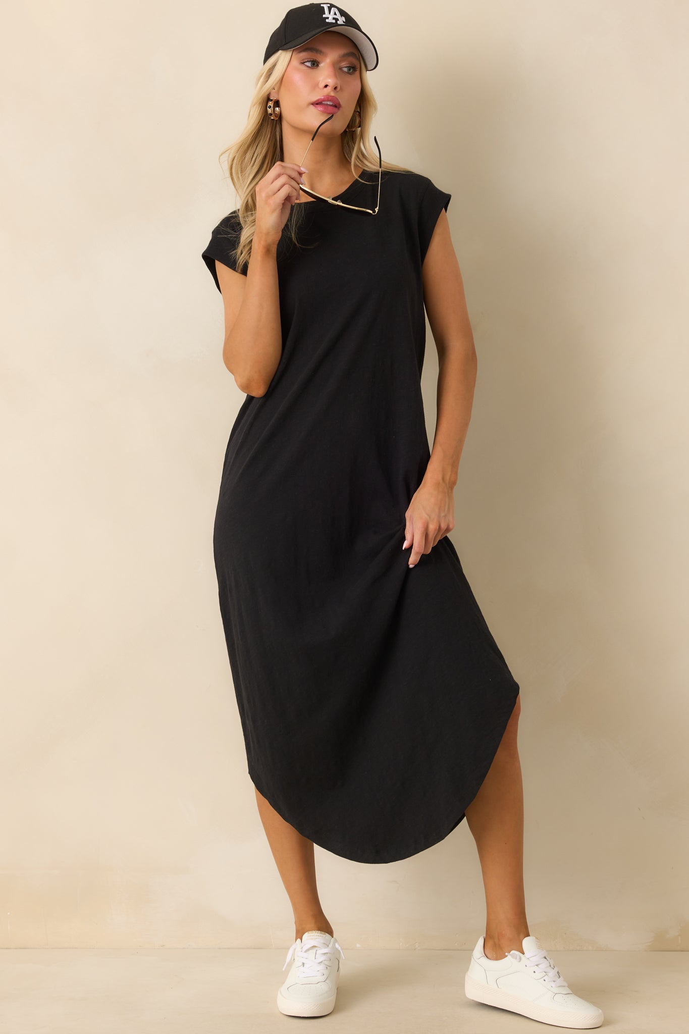 Front-facing black dress highlighting relaxed fit and scoop bottom hem.