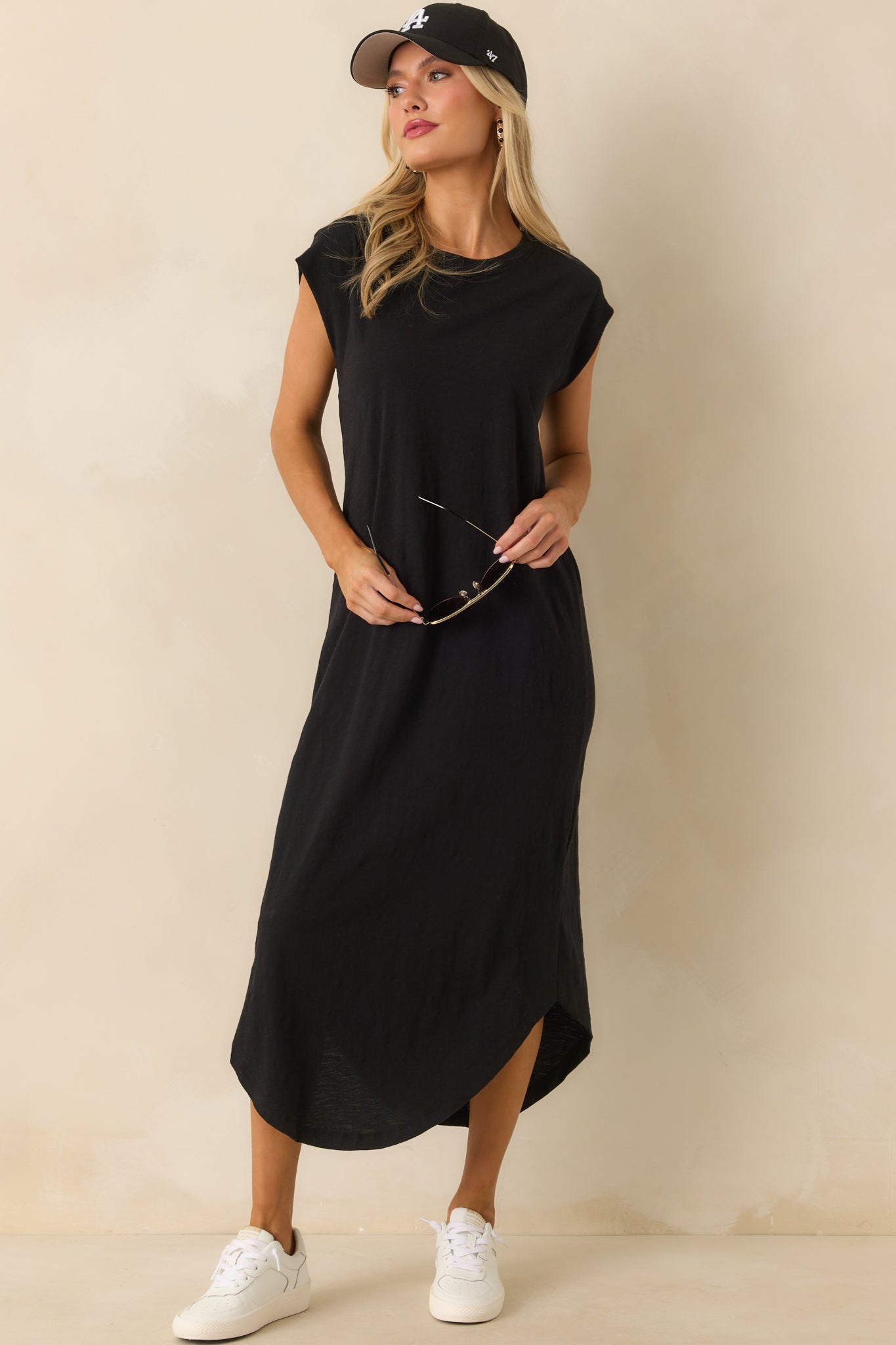 Full-length view of the black dress emphasizing smooth fabric and simple, relaxed shape.