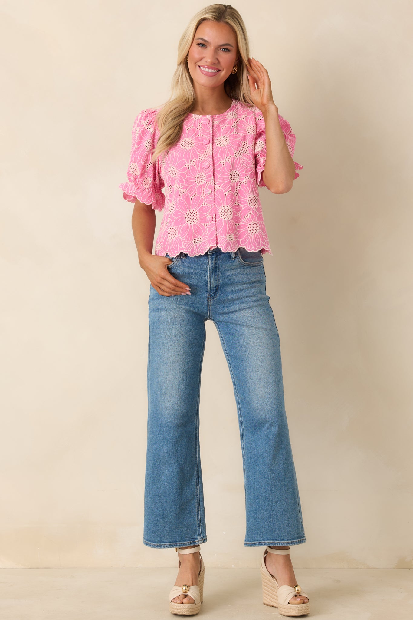 Romantic embroidered top featuring delicate eyelet detailing and button-front closure.