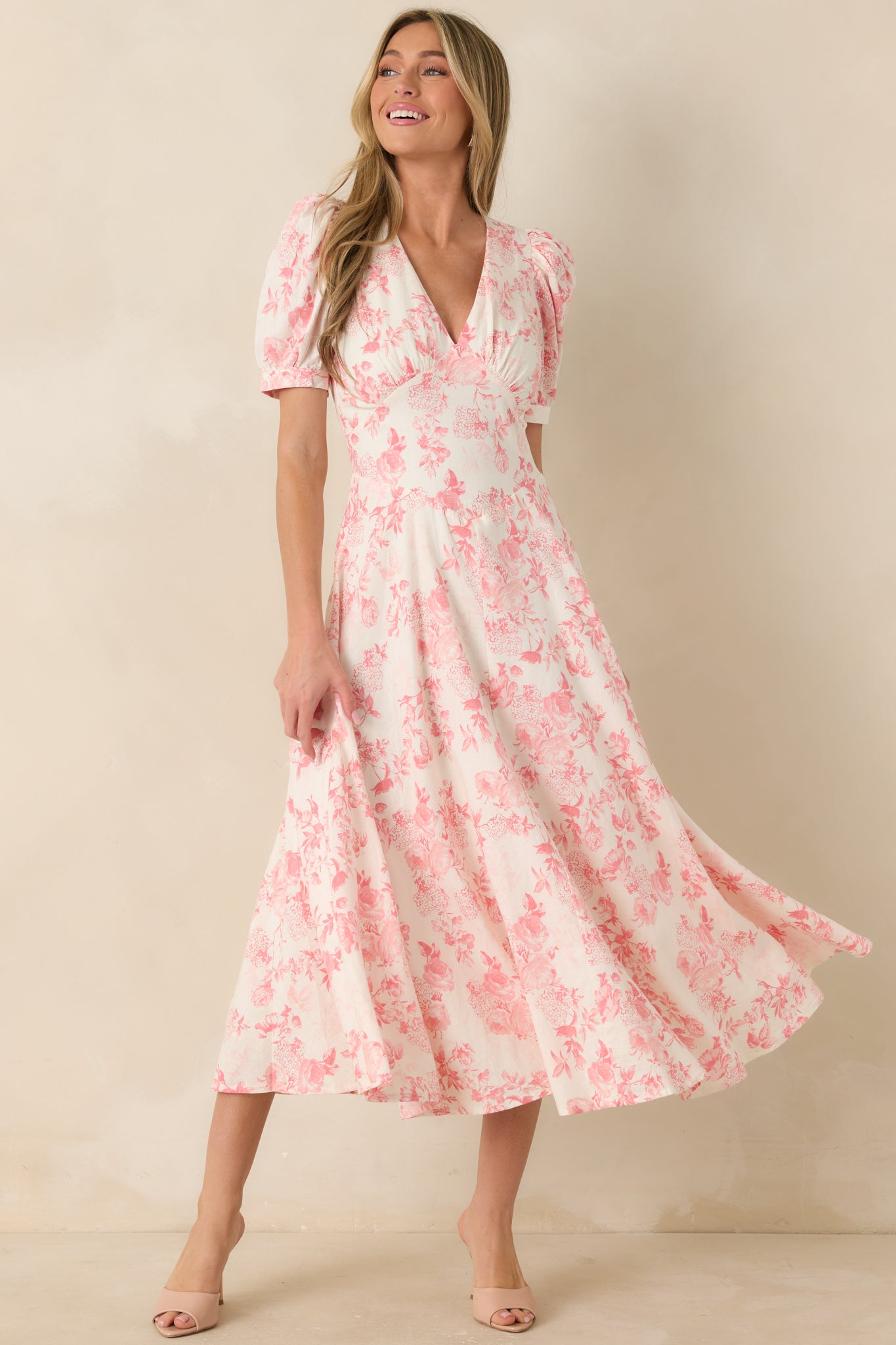 Coral floral maxi dress featuring puff sleeves, tailored bodice panels, and relaxed full-length skirt.