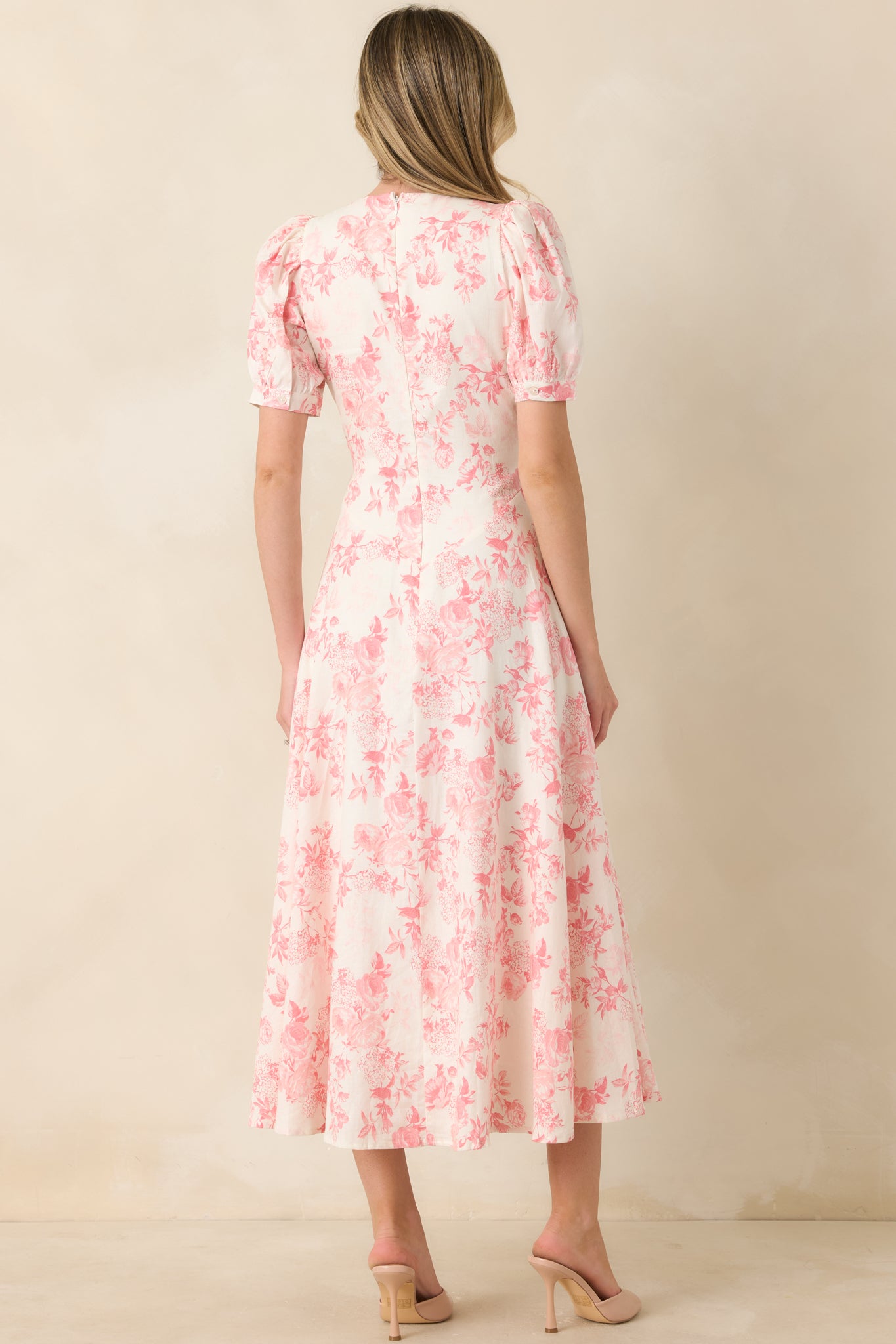 Rear view of coral floral maxi dress with short puff sleeves and concealed zipper closure.