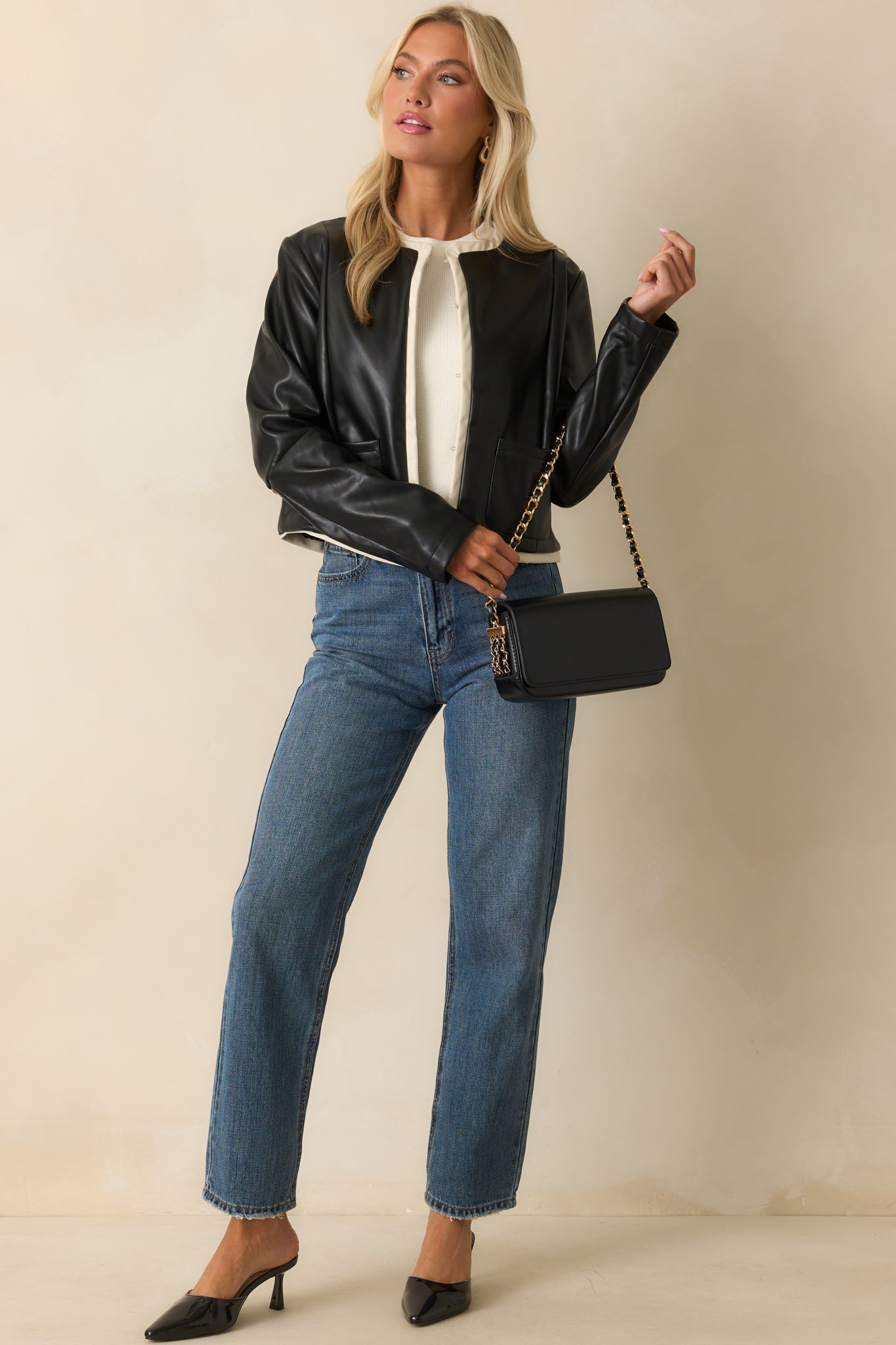 Black jacket featuring a round neckline and ivory faux leather trim for a sleek, modern look.