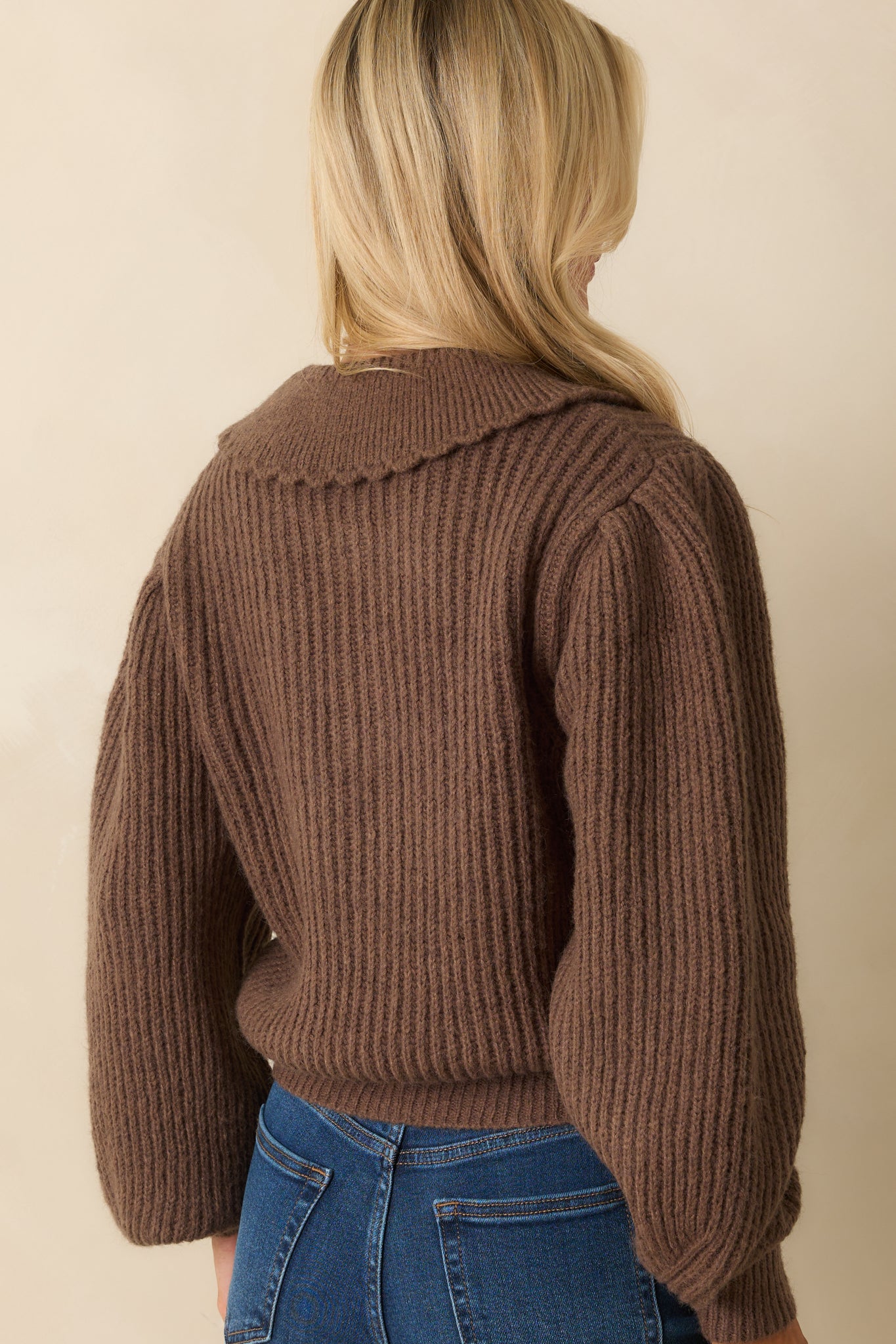 Rear view of brown cardigan showing ribbed texture, balloon sleeves, and slightly cropped hemline.