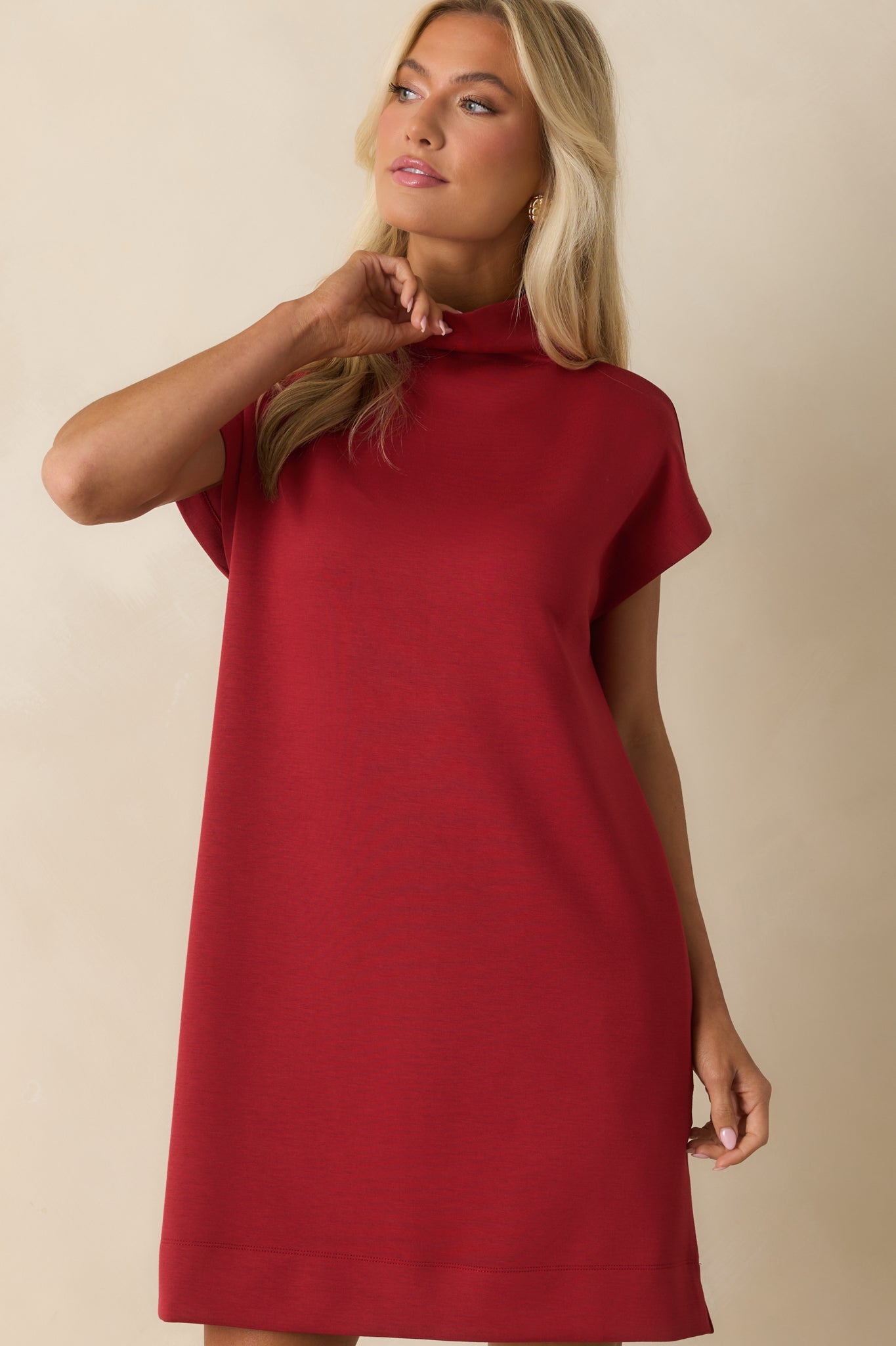 Mock neckline and sleek shoulder design on the red mini dress.