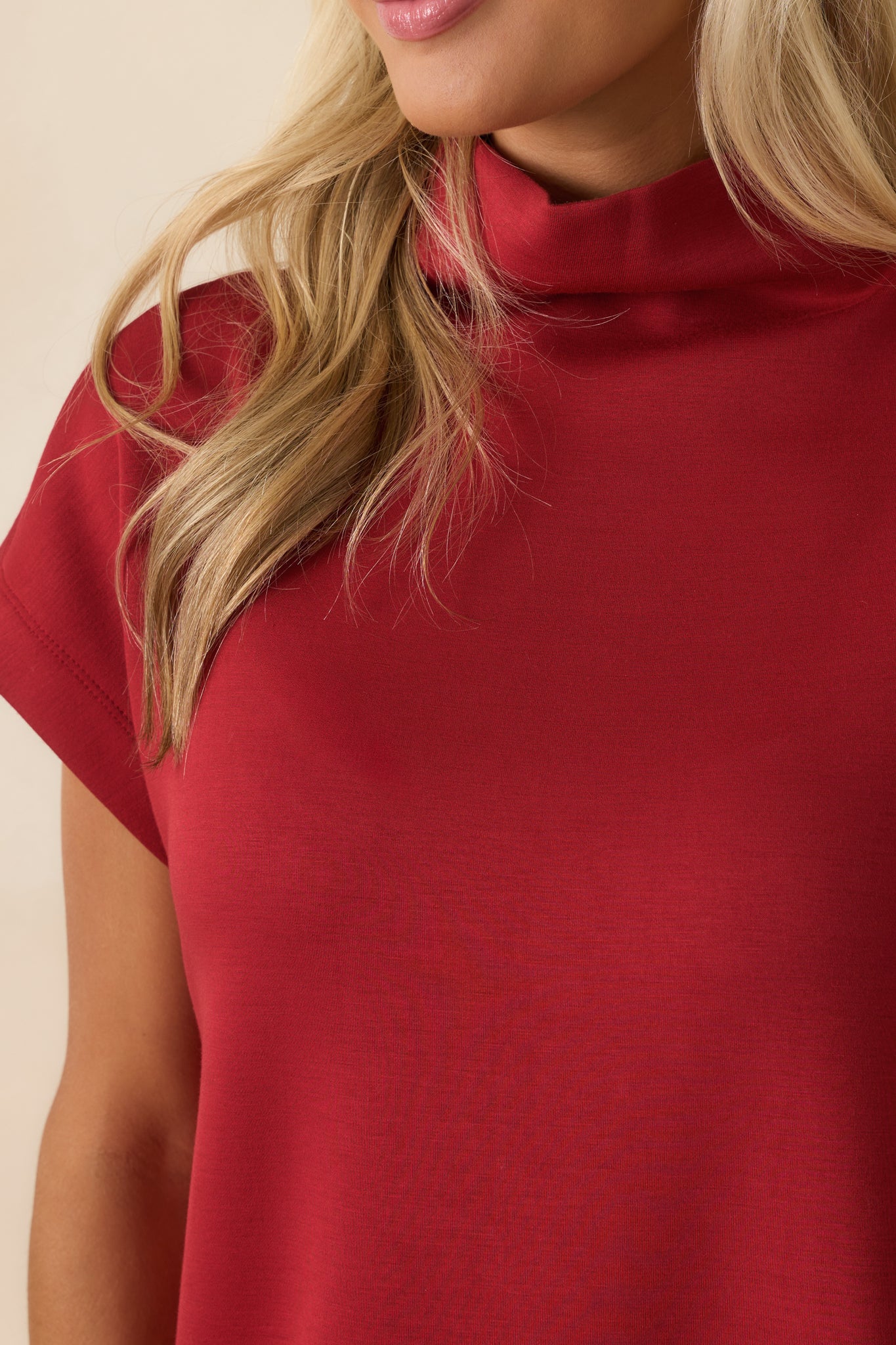 Detailed look at the fabric texture and clean stitching on the red dress.