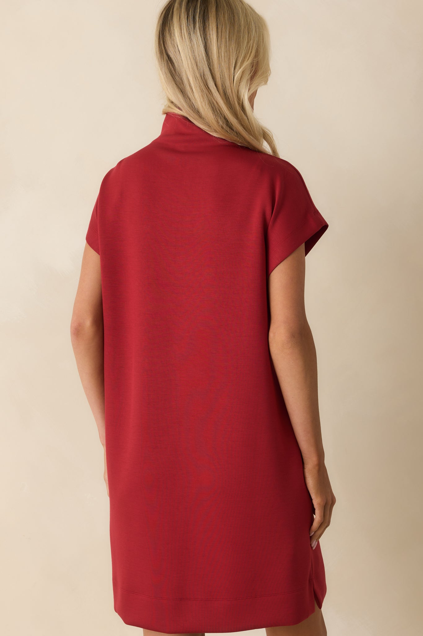 Red mini dress from the rear with a straight silhouette and mock neckline finish.