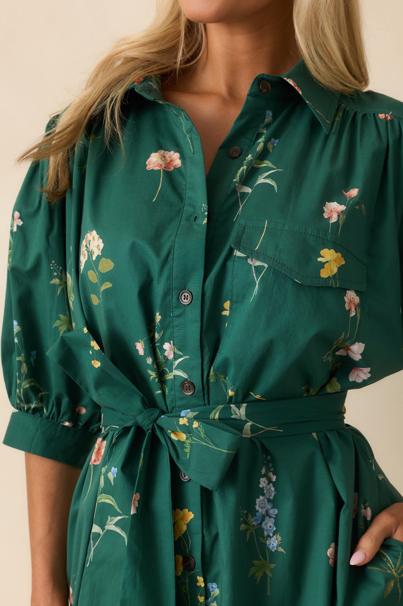 Close-up of the collared neckline, functional button front, and chest patch pocket on the floral dress.