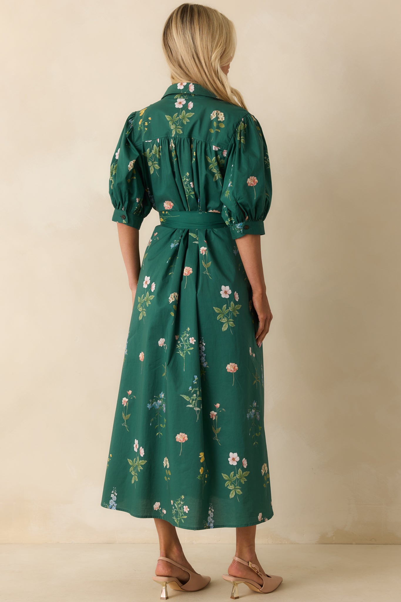 Rear view of the forest green maxi dress showing the smooth back panel, puff sleeves, and flowy skirt.