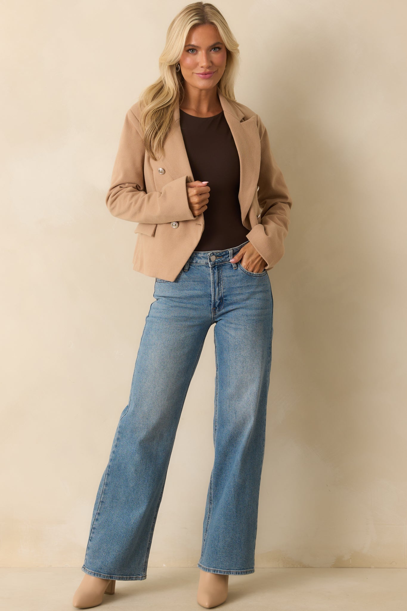 Another complete profile of the tan blazer capturing its lapel collar and long sleeves.