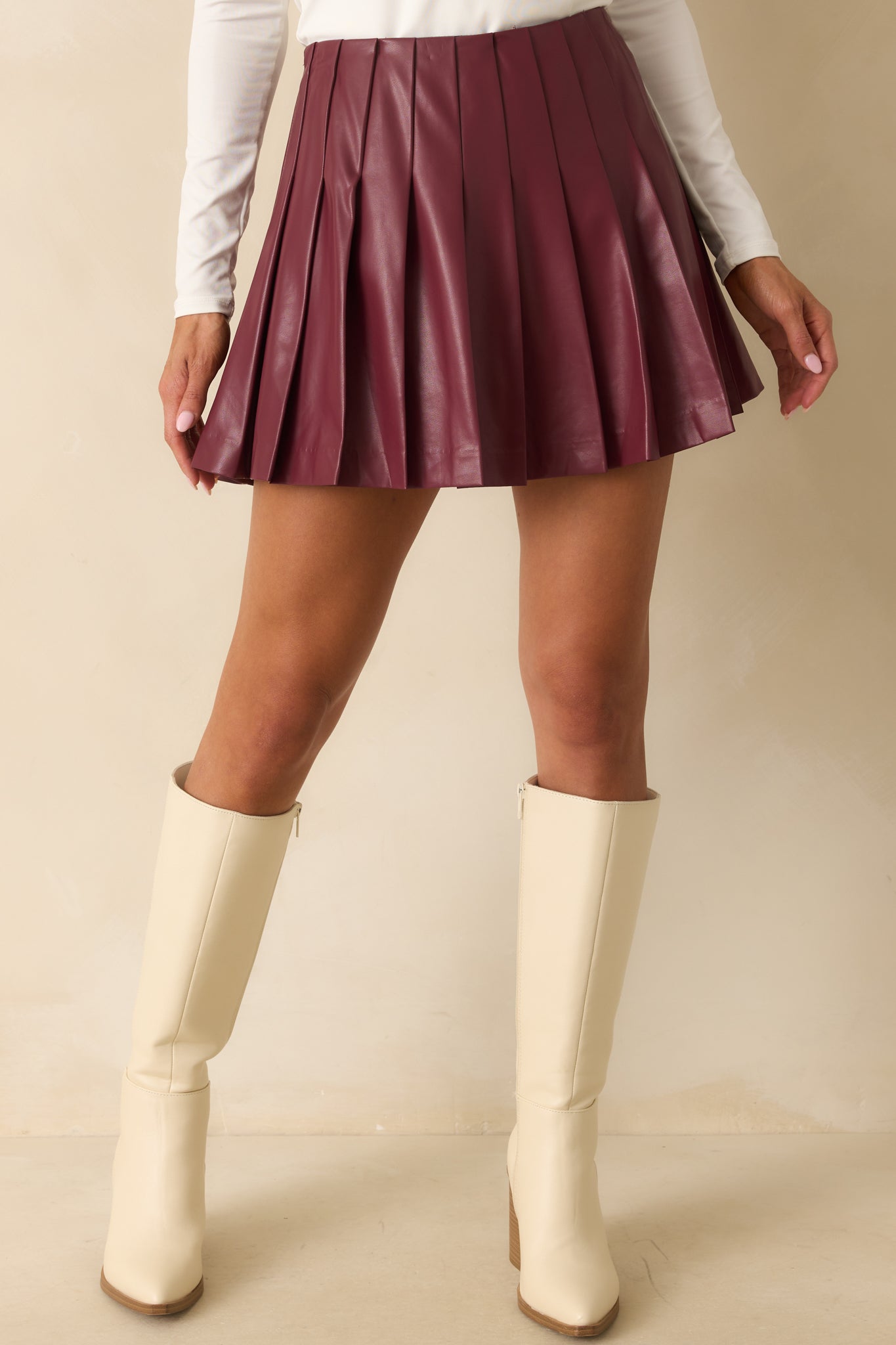 Detail showing the built-in shorts lining and pleated design of the wine red skirt.