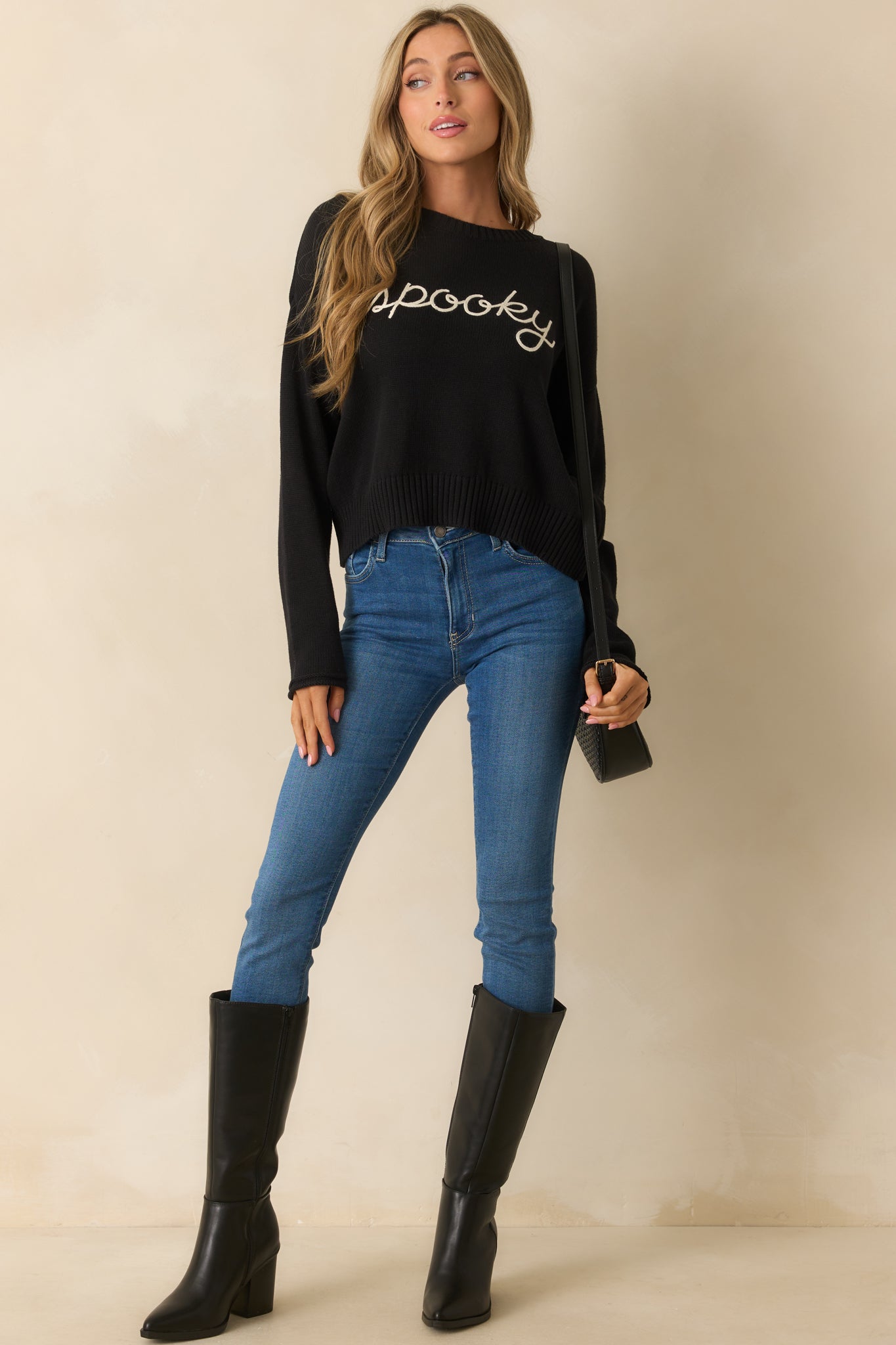 Black cotton sweater with ivory “spooky” embroidery in bold script across the front.