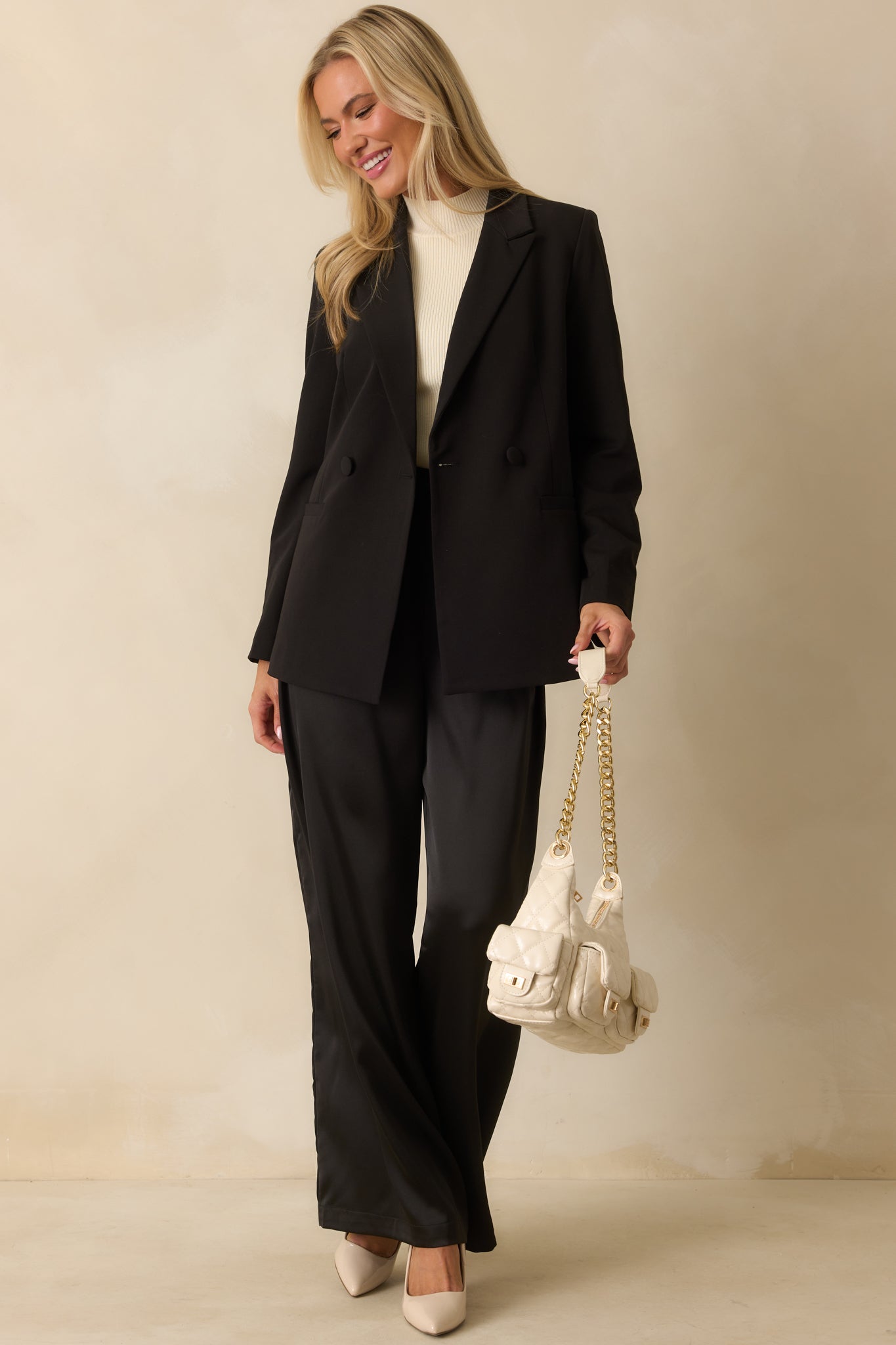 Front view of black blazer featuring button closures and lightweight shoulder pads.