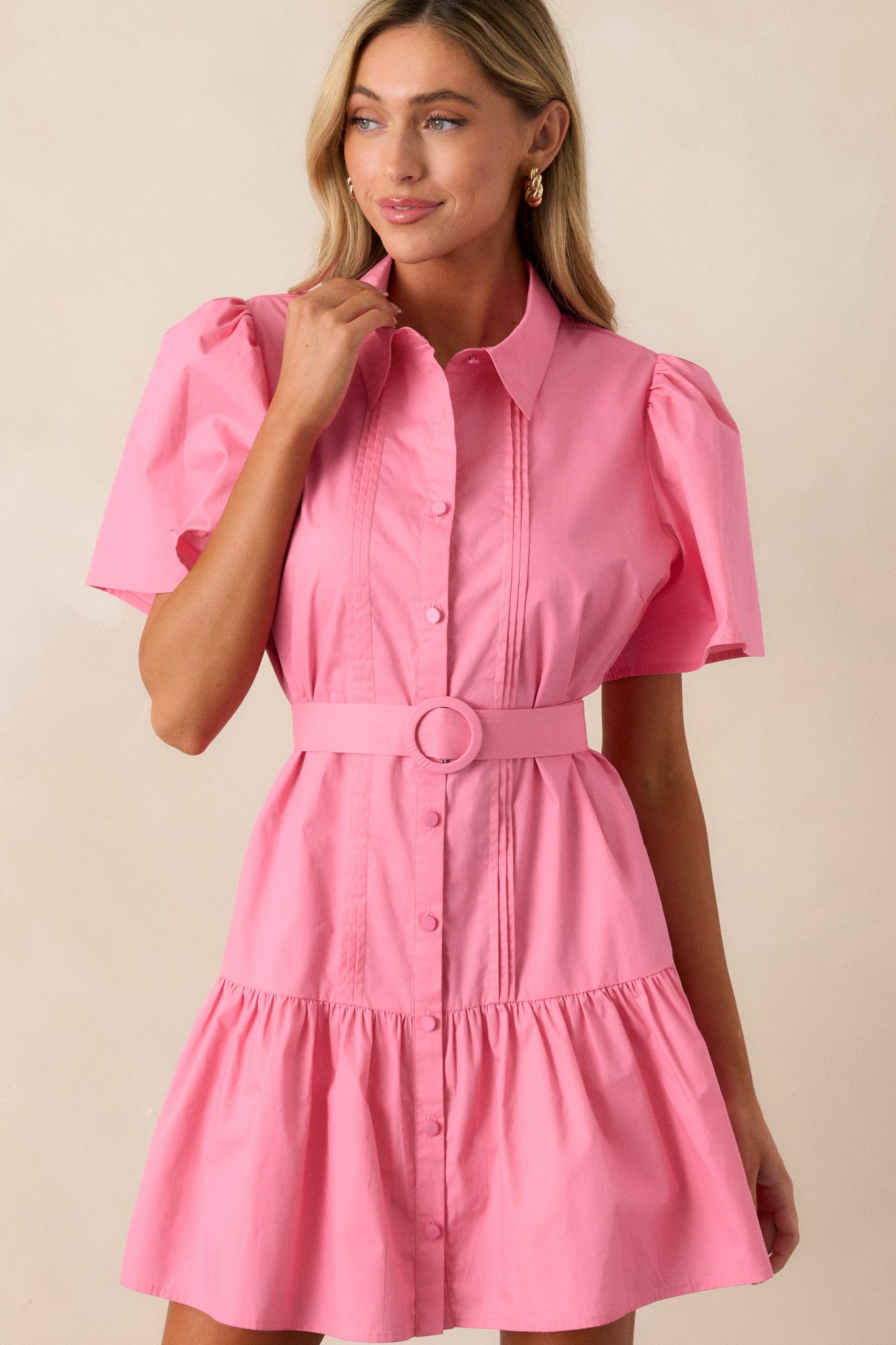 A close-up of the pink mini dress's collared neckline and faux pearl button front, highlighting its elegant details.