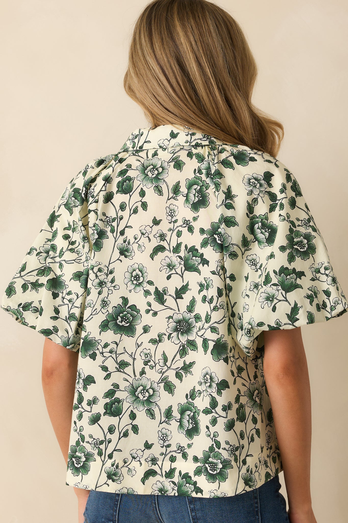Rear view of the green floral top showing the full relaxed fit and short sleeve shape.