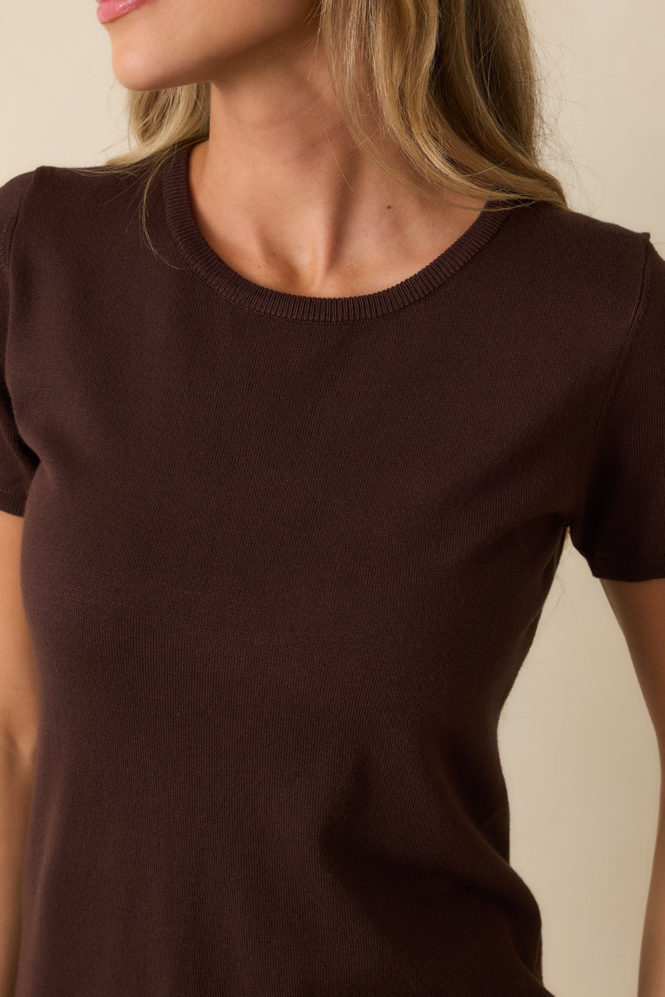 A close-up of the top showing the fine knit texture, ribbed trim, and dark brown color.