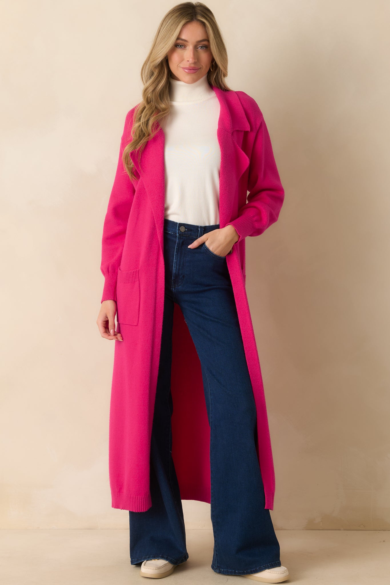 Hot pink longline cardigan highlighting the smooth knit fabric and relaxed fit with long sleeves.