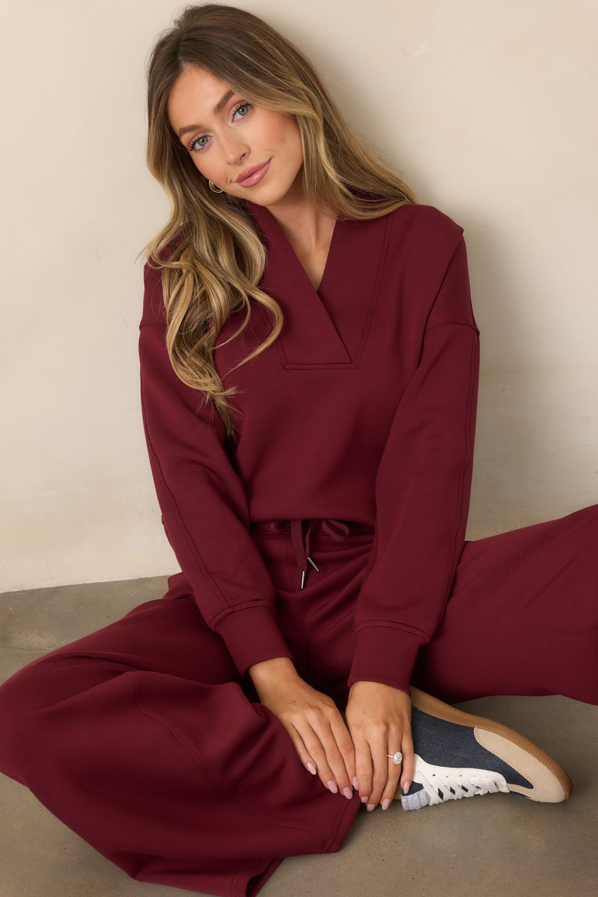 Deep red V-neck sweatshirt with a wide collar, dropped shoulders, and long sleeves