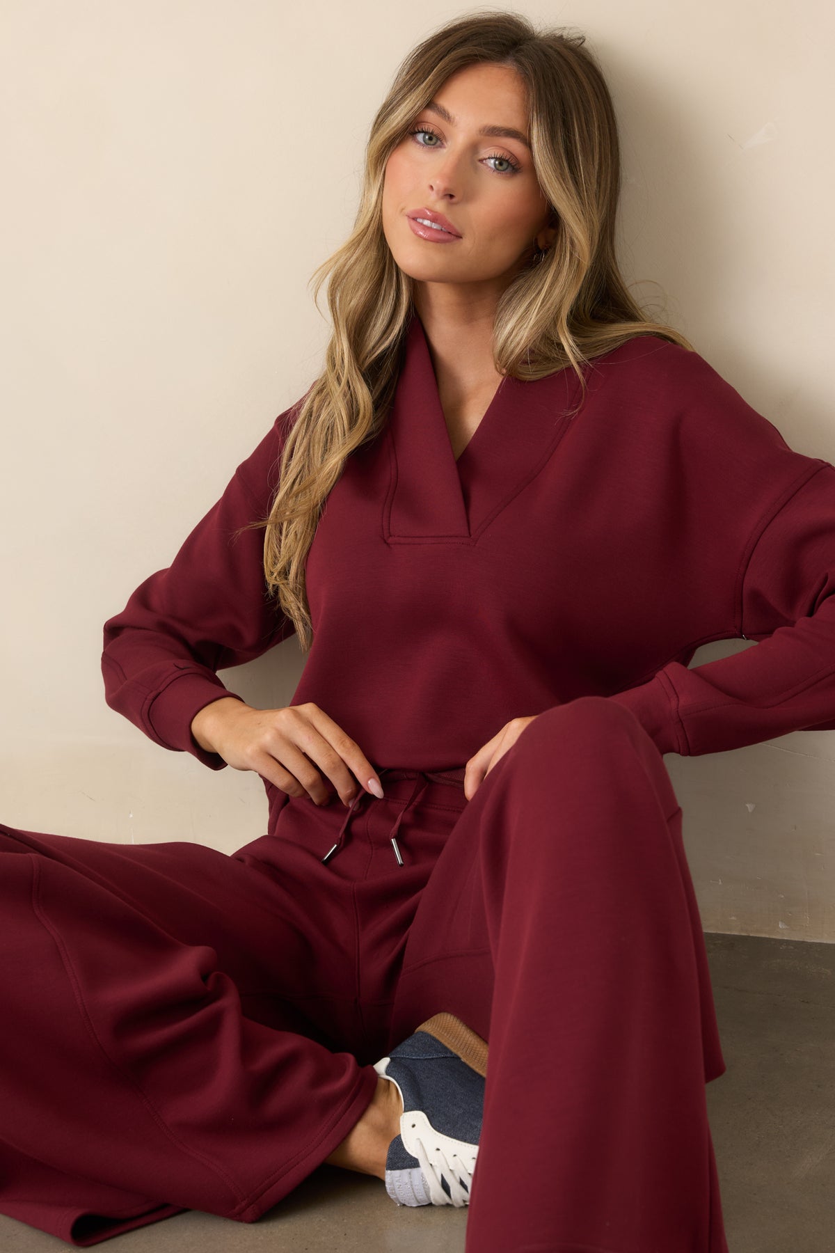 Red long sleeve sweatshirt featuring a structured V-neckline and relaxed silhouette