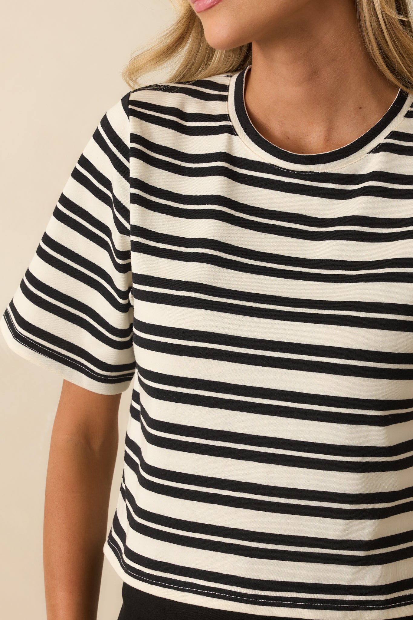 Close-up of the soft jersey fabric and crew neckline with black and ivory stripes.
