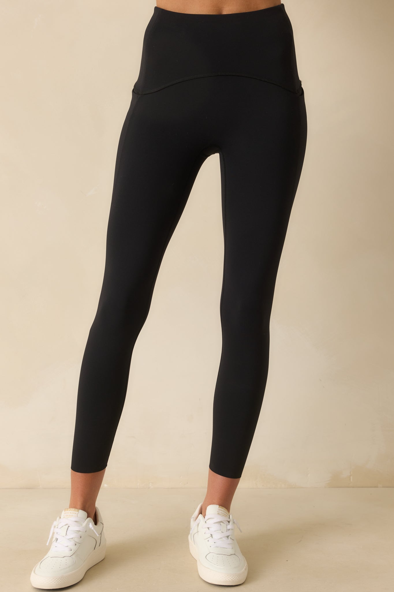 A cropped shot of the black leggings highlighting the fitted leg and smooth finish.