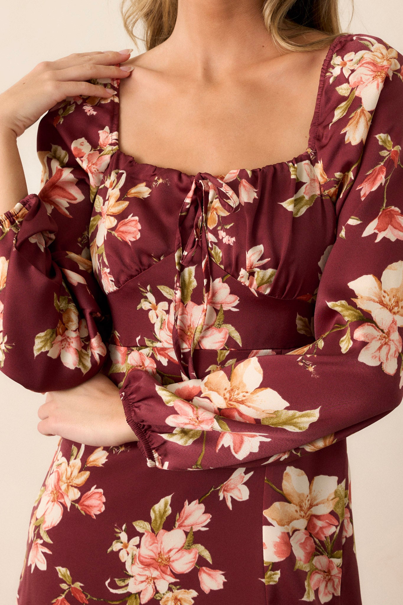 Close-up of the squared neckline and self-tie bust detail, highlighting the floral pattern and texture of the fabric.