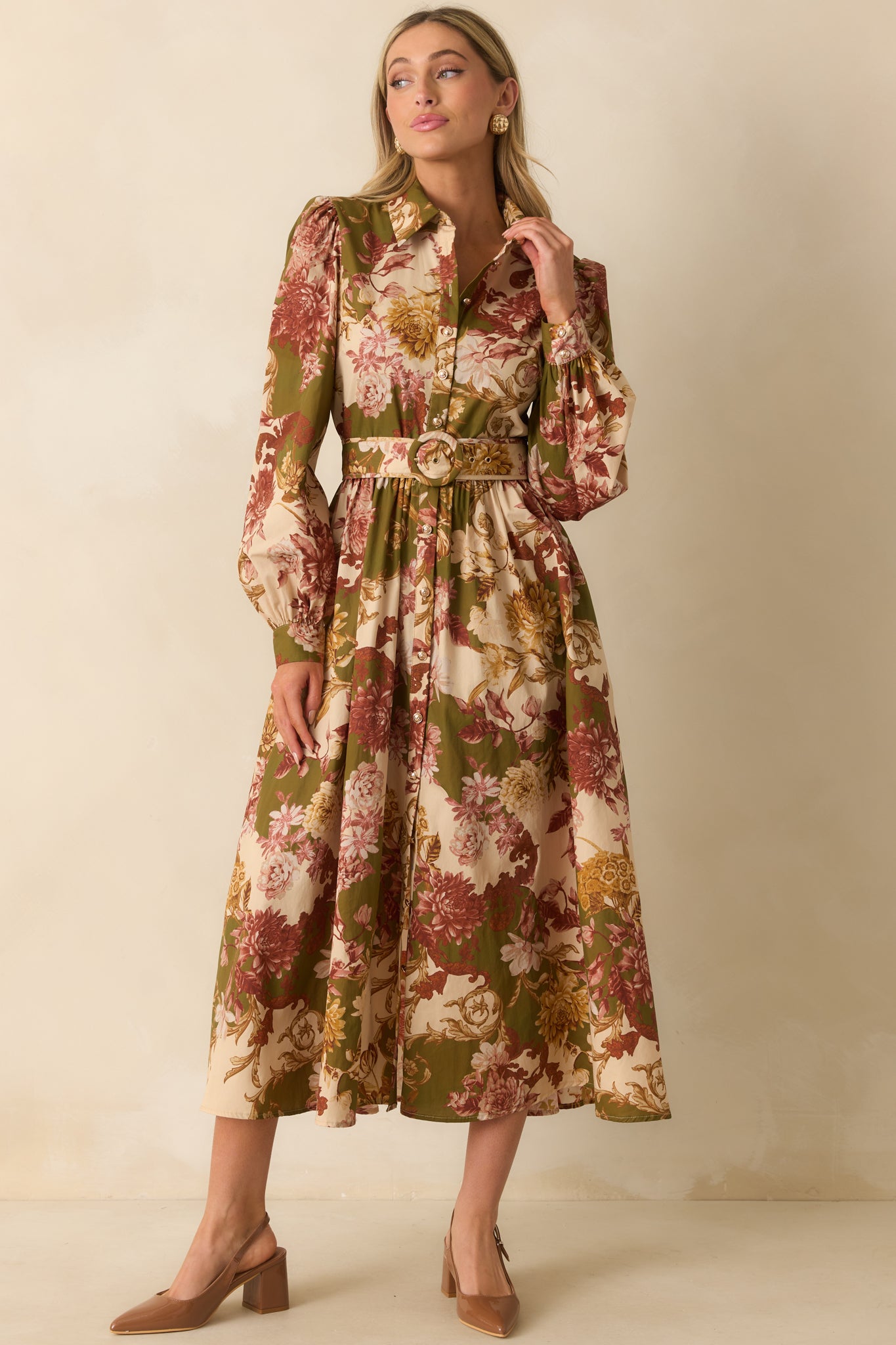 Olive green dress adorned with vibrant floral print, showcasing long puff sleeves, buttoned cuffs, and a button front closure.