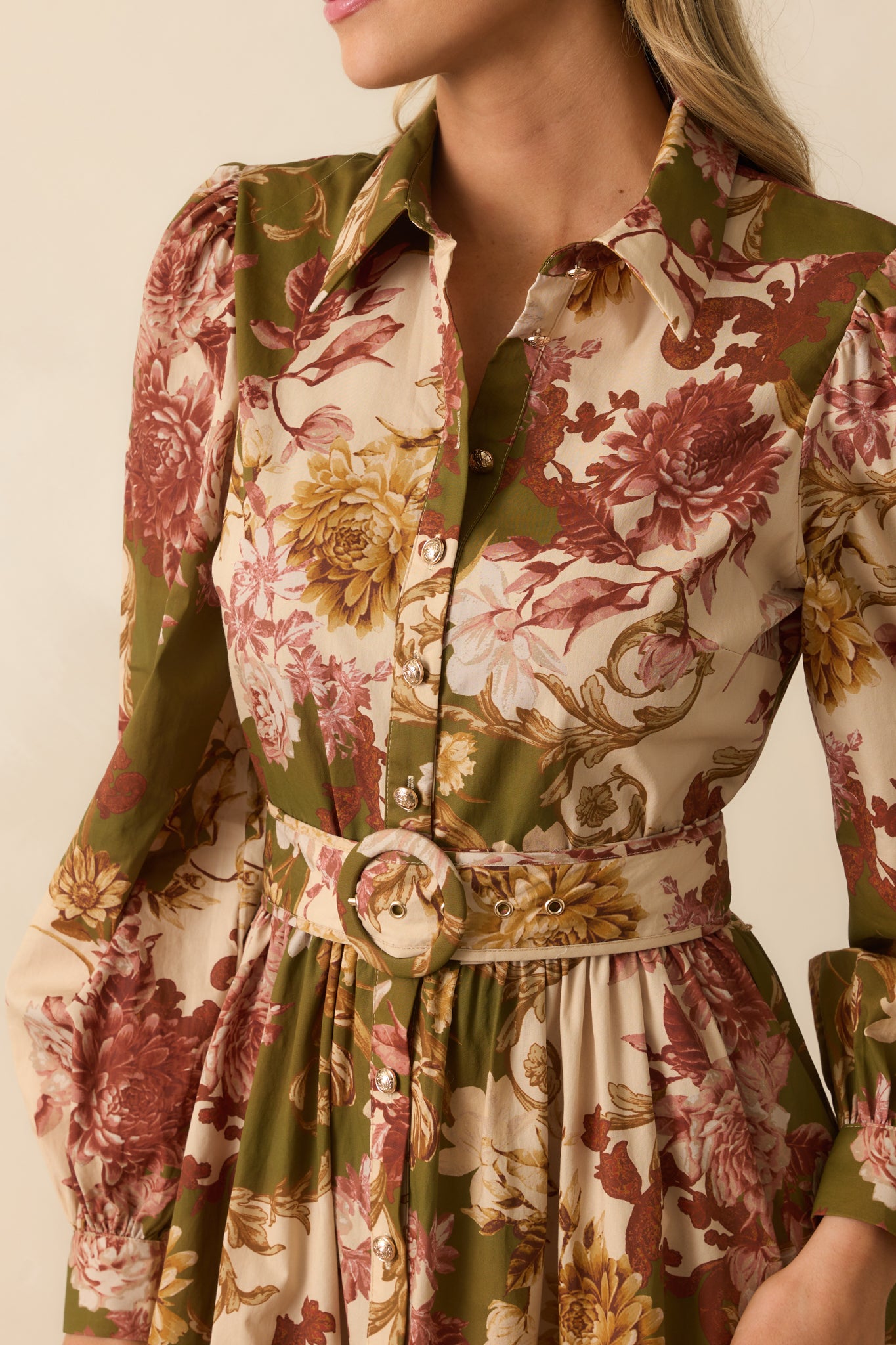 Close-up of the olive green dress’s collared neckline, multicolor floral print, puff sleeve detail, and functional buttons.